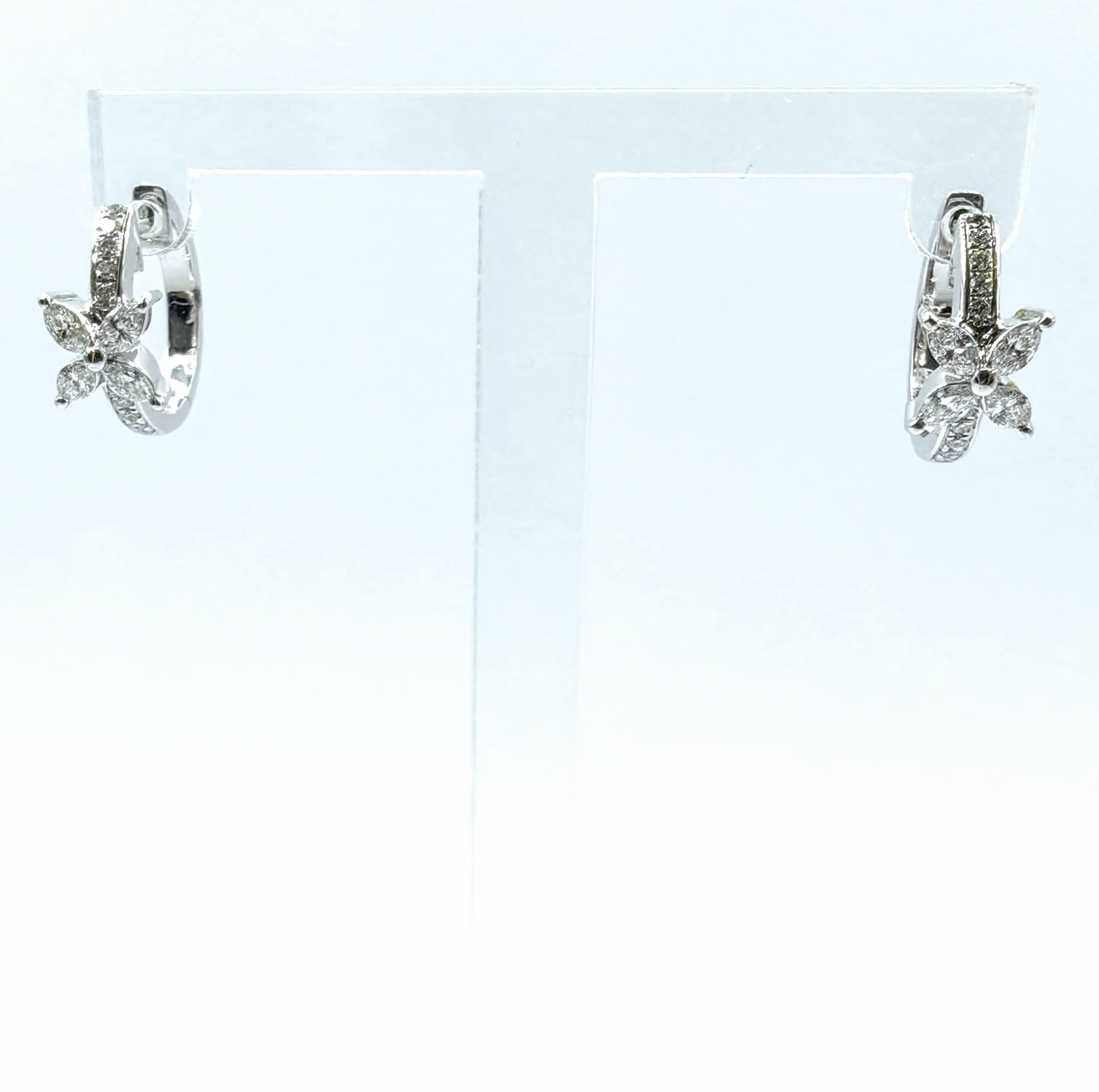 La elegancia botánica florece en estos encantadores pendientes de aro, donde delicadas flores de diamantes crean cautivadores puntos focales. Cada pendiente presenta un elegante motivo floral elaborado con diamantes talla marquesa que forman pétalos