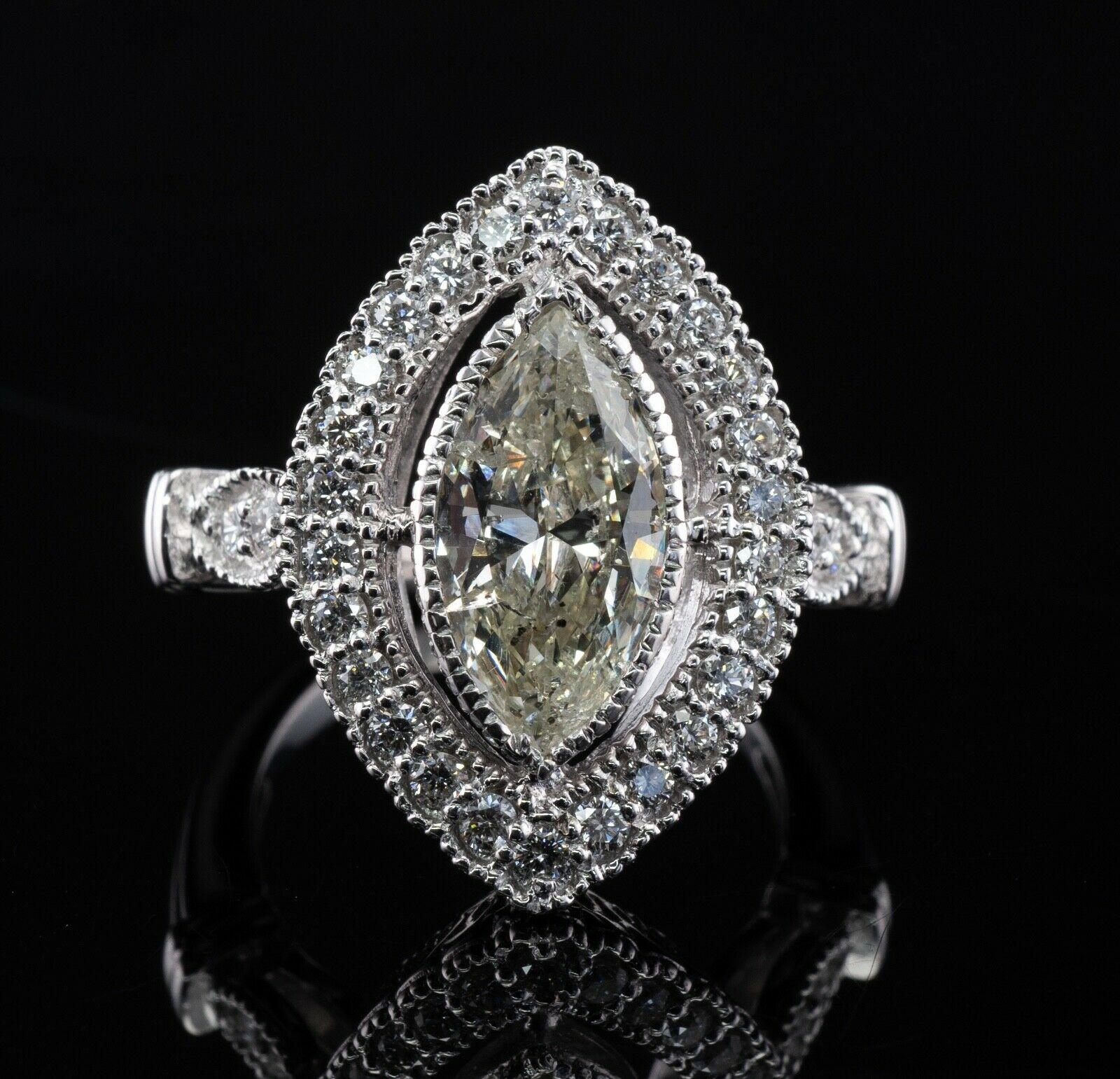 This amazing estate ring is finely crafted in solid 18K White Gold. Hallmarked Del Co. The center marquise cut diamond is 2.50 carats of I-2 clarity and K color. 26 surrounding round brilliant cut diamonds and 4 side diamonds are VS1 clarity and G