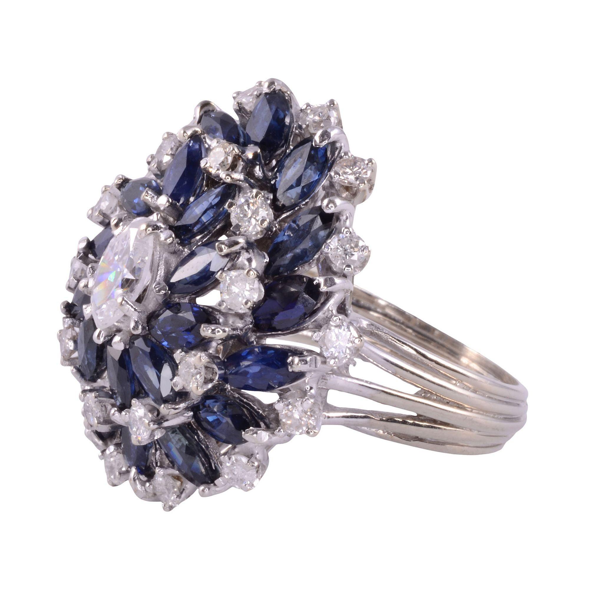Estate marquise diamond & sapphire cocktail ring, circa 1980. This cocktail ring is crafted in 18 karat white gold and features diamonds and sapphires in wire basket style setting. The center .50 carat marquise diamond has I1 clarity and F color.