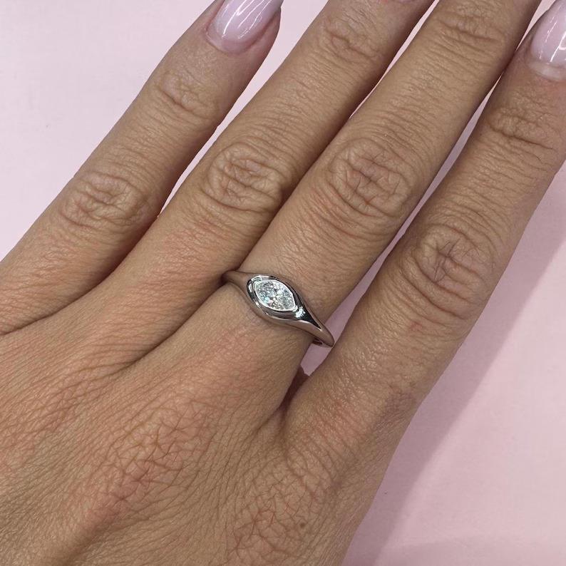 14 White gold signet ring featuring a center Marquise diamond weighing 0.27 carats in a high polish finish. Color G Clarity VS 
2.06 Grams

More Signet & Fashion Rings Available.
Message for Pictures & Details
Search Harbor Diamonds