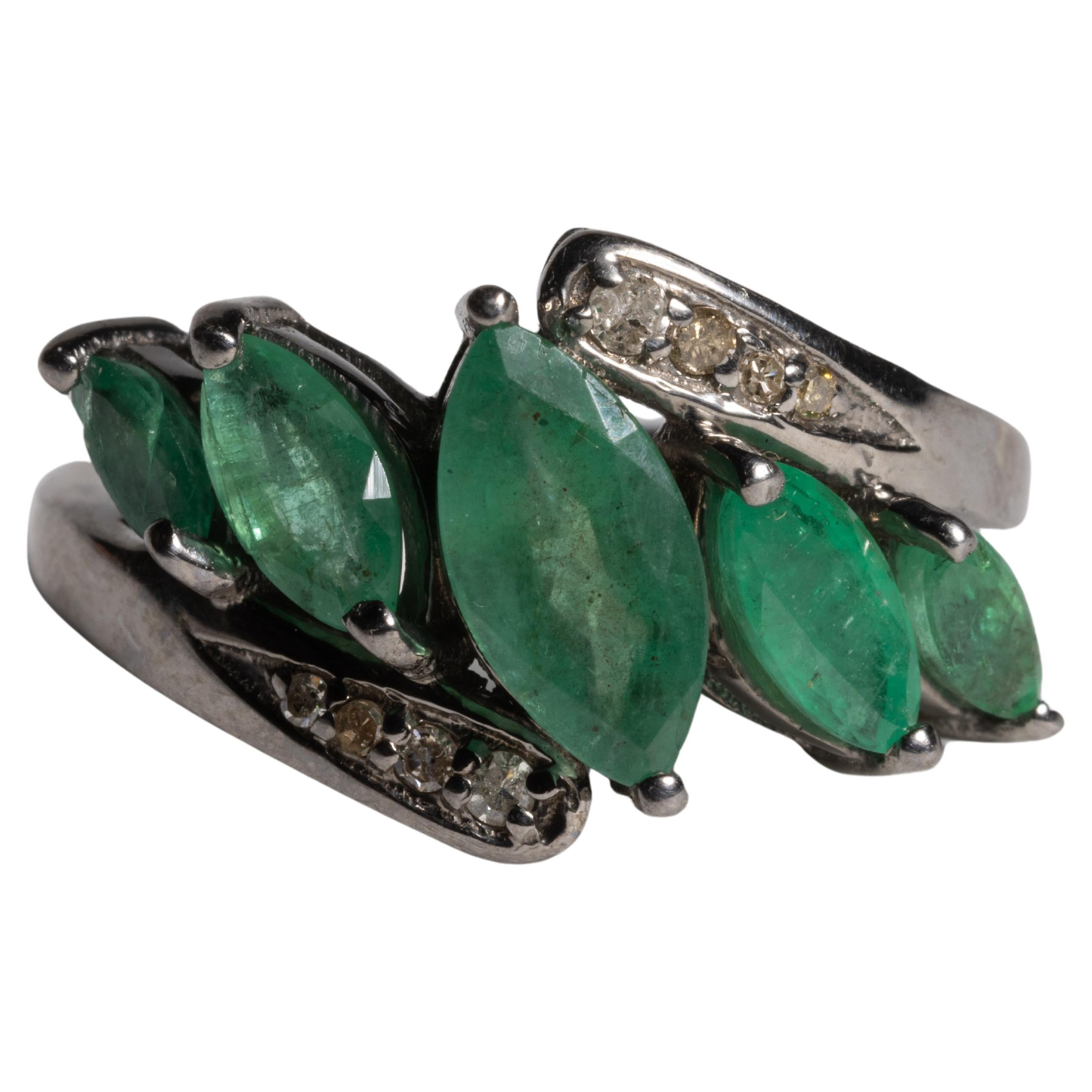 Ein Ring mit gebündelten marquisefarbenen Smaragden, der  von einem größeren zentralen Edelstein ab. Oben und unten mit runden Diamanten in Pave`-Fassung eingefasst.  In oxidiertem Sterlingsilber gefasst.  Smaragde insgesamt 2,06 Karat; Diamanten