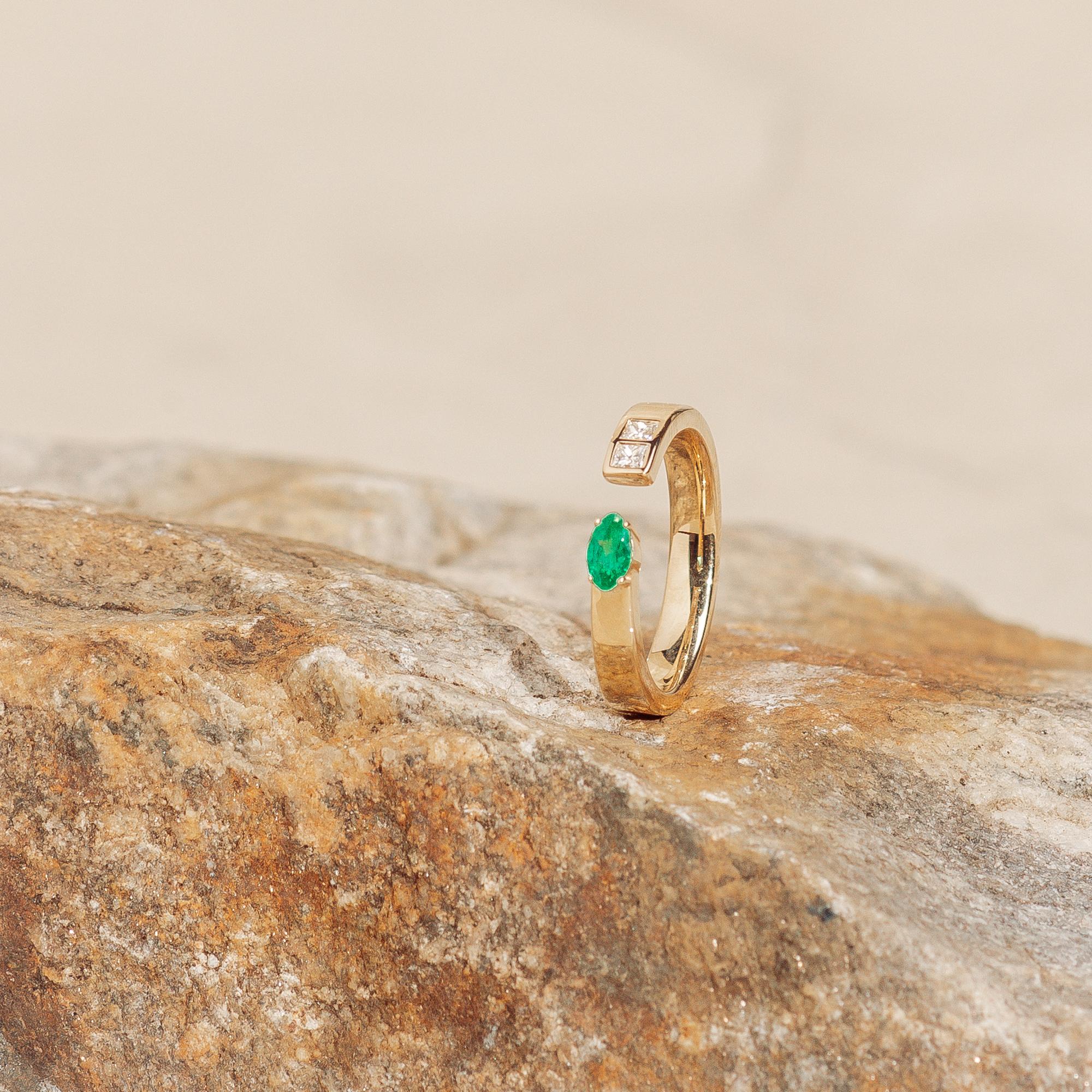 Unico anello con gambo diviso, in oro giallo massiccio 14k. Presenta 2 diamanti taglio princess incastonati a filo per un totale di 0,21 ctw. Lo smeraldo marquise è incastonato e misura 0,257 carati. Taglia 7.