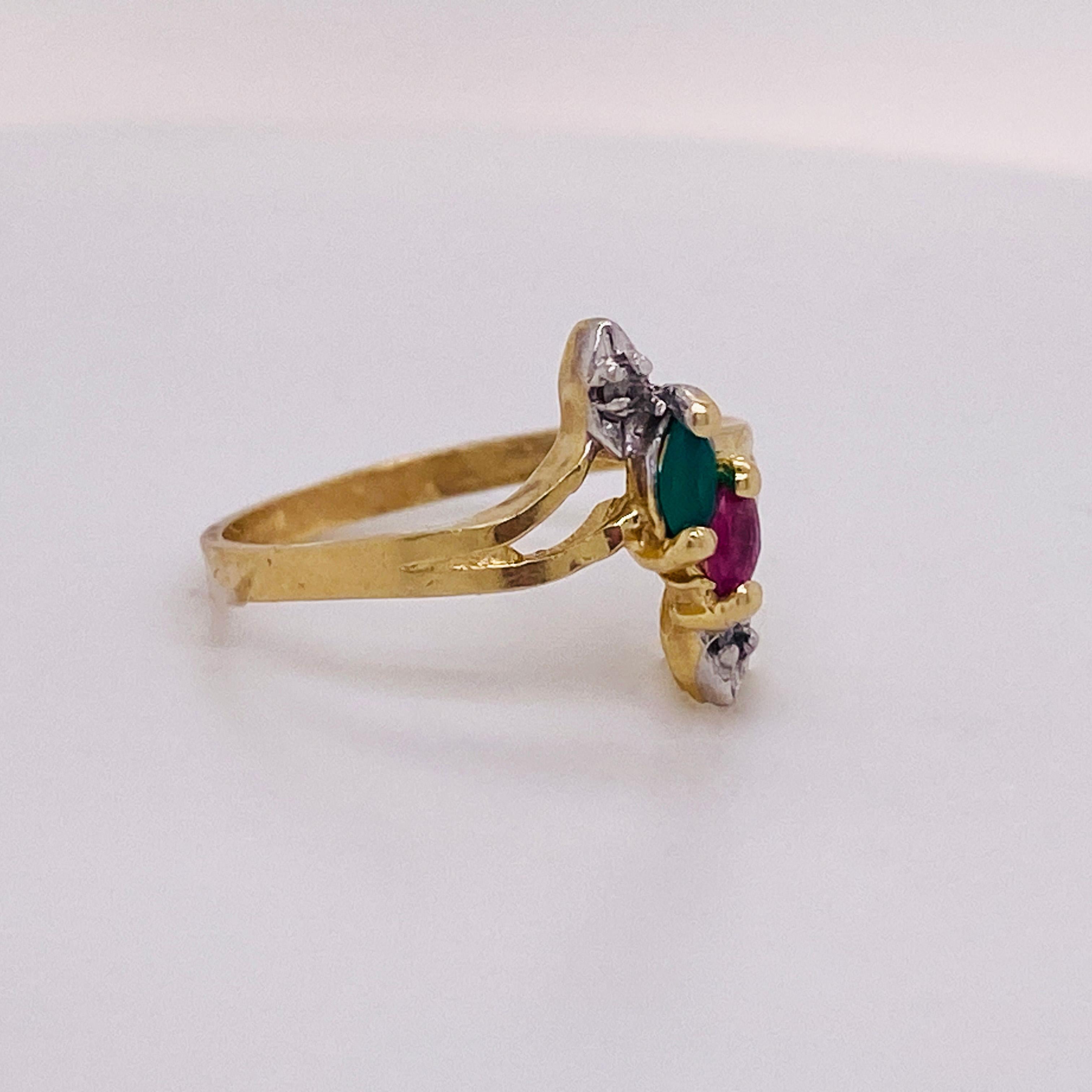 This unique marquise shaped ring has a marquise emerald and a marquise ruby flanked by a diamond. This ring looks amazing on any finger. The ruby and emerald are amazing quality! The unique split band gives it a very classy look! The ring is a size