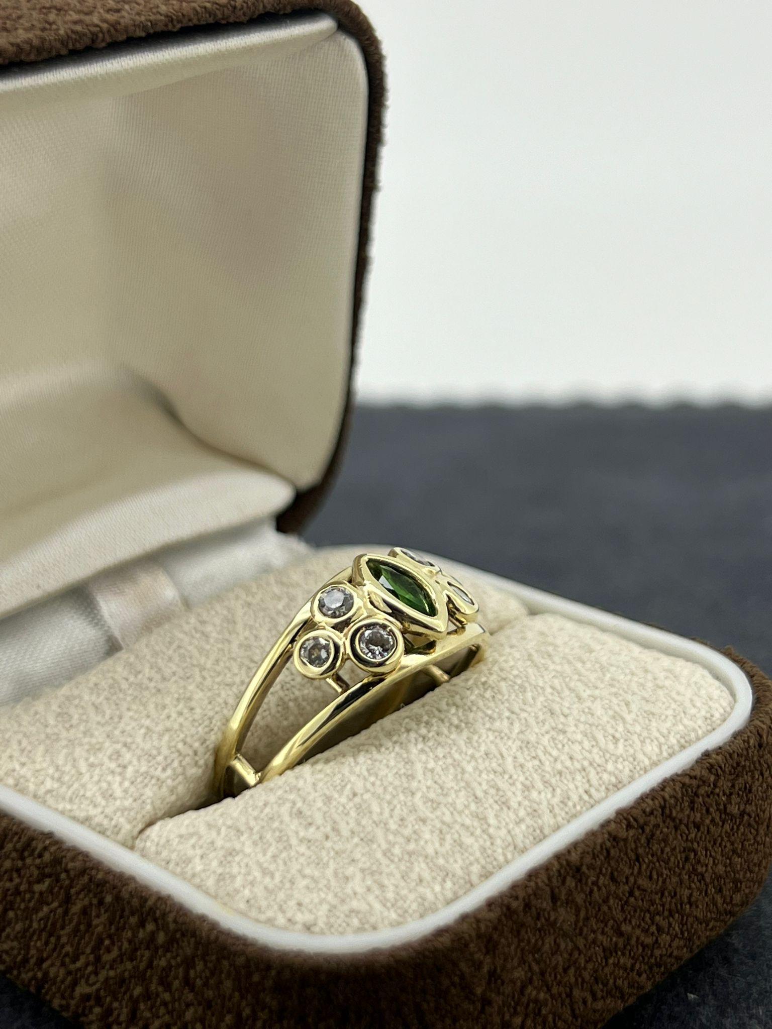 Realizado en oro amarillo de 9 quilates,
el anillo centra una marquesa Gilson 

Esmeralda sintética
de 0,25ct aprox. (6,5mm x 3mm)
de un magnífico y vivo color verde hierba y 
excelente claridad, engastado en bisel  

Flanqueado por 6 diamantes