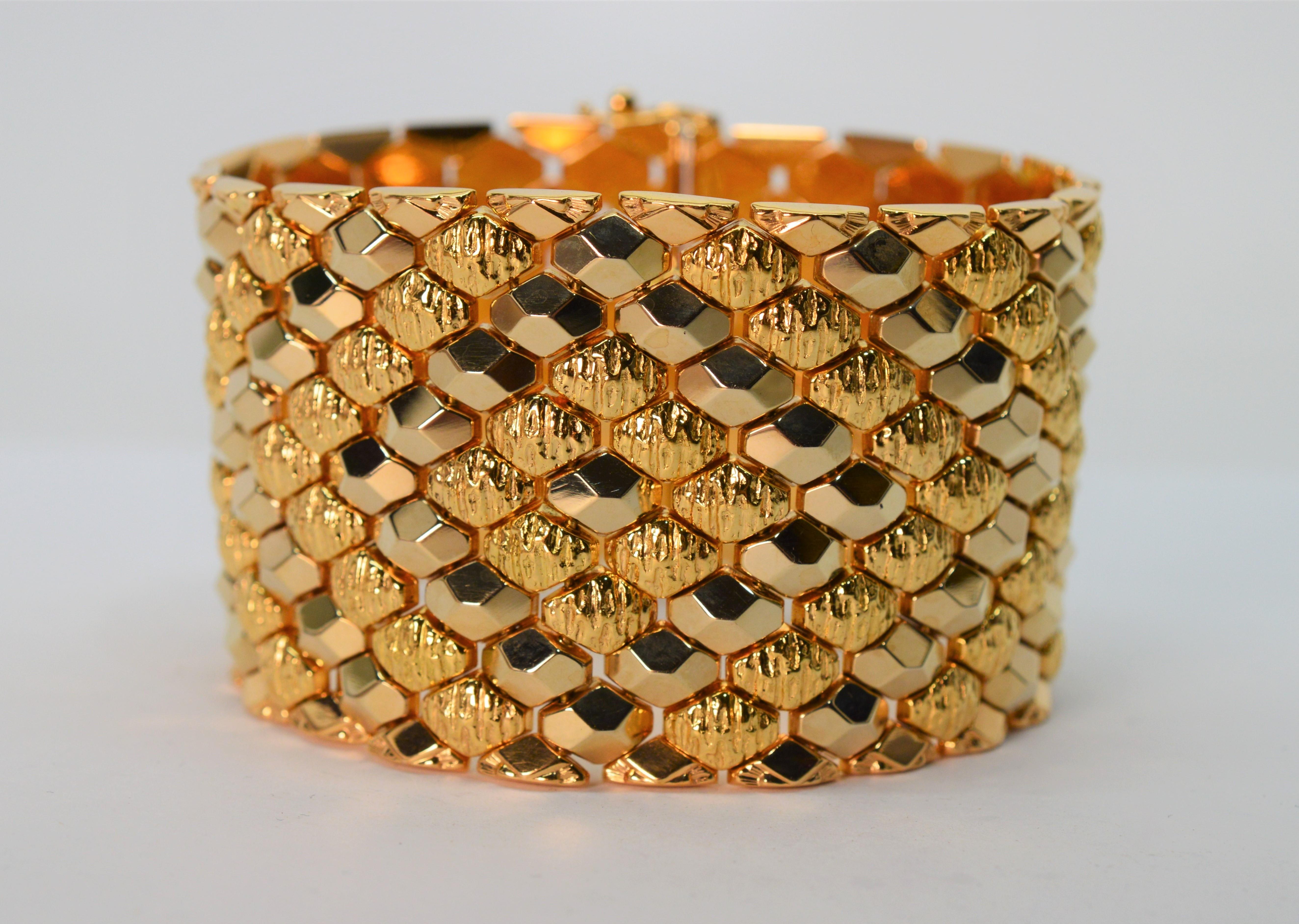Audaciously gold, this finely Italian made bracelet is superb in rich eighteen karat 18K yellow gold. Striking marquise links in complementing bright polish and textured finishes boldly wraps the wrist in this generous 1-5/8 inch wide flexible cuff