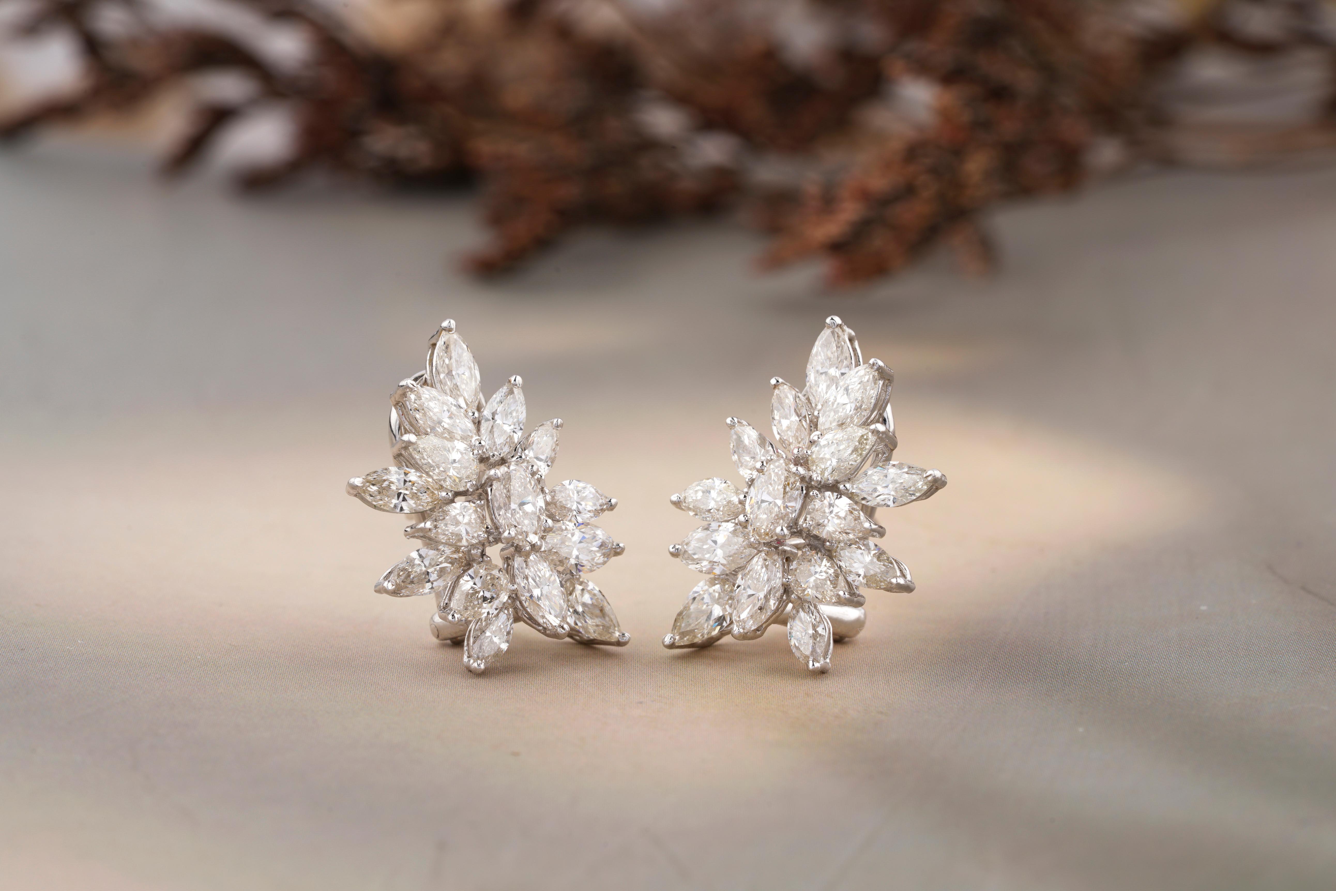 Elevate your elegance with these breathtaking diamond earrings featuring dangling pearls. Designed to perfection, these earrings showcase a stunning array of marquise-cut, oval and pear-cut diamonds arranged in a floral motif, accented by delicate