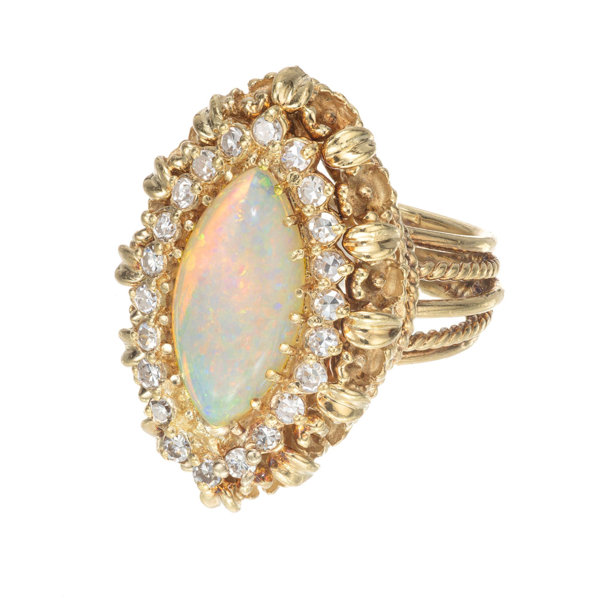 1950's opal and diamond ring. 3.50ct Marquise cut center opal, 18k yellow gold handmade wire cocktail setting with a halo of 22 round single cut diamonds. The opal is bluish green with red and orange flashes. 

1 Marquise cut opal 3.50cts 
22 round