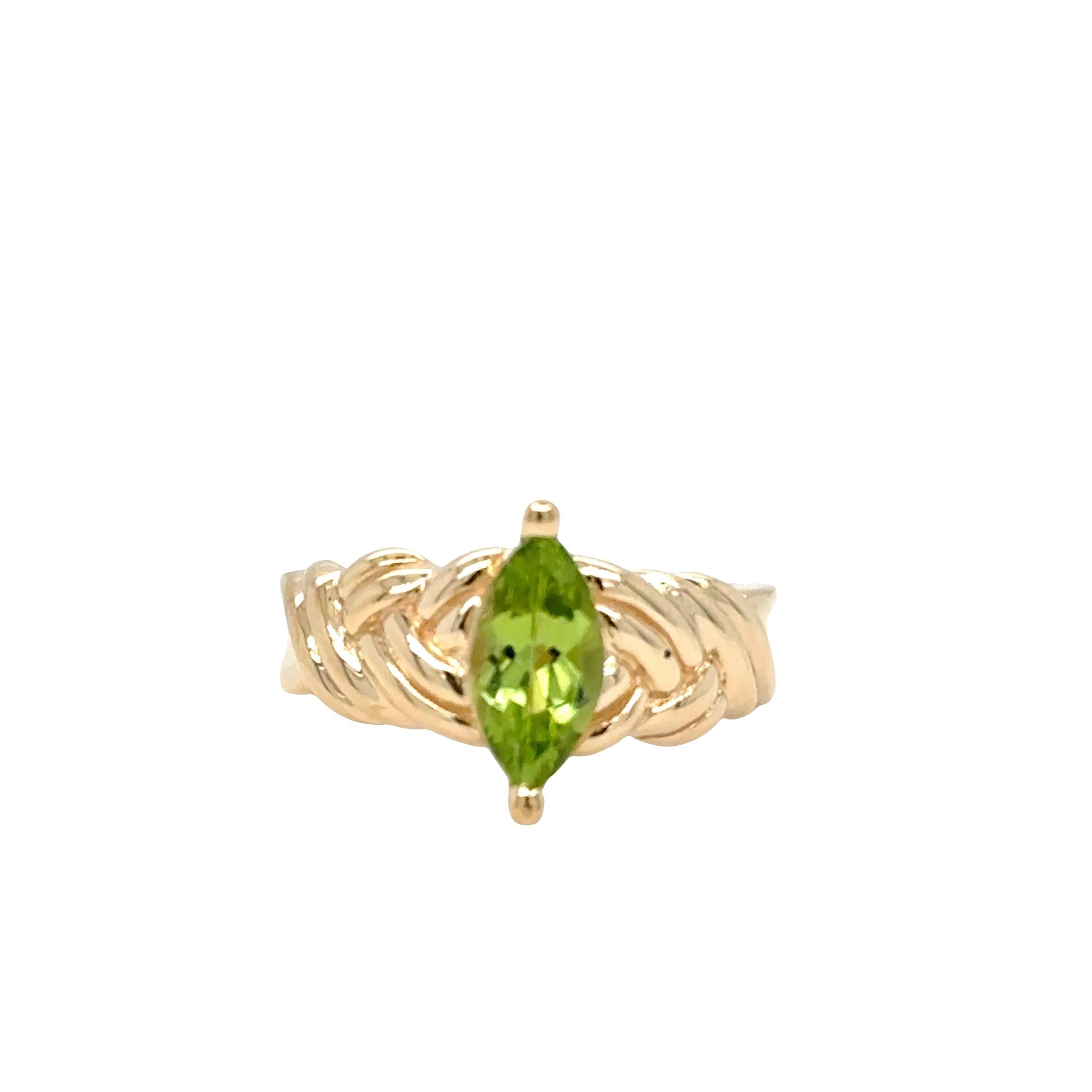 Classic with a textured twist, this marquise-cut peridot ring is set in a distinctive woven rope-style band crafted from solid 14k yellow gold. The vivid green peridot is oriented in a north-south prong setting, elongating the finger and drawing the