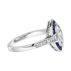 Anillo de oro blanco estilo Art Déco con diamante talla marquesa y halo de zafiro azul