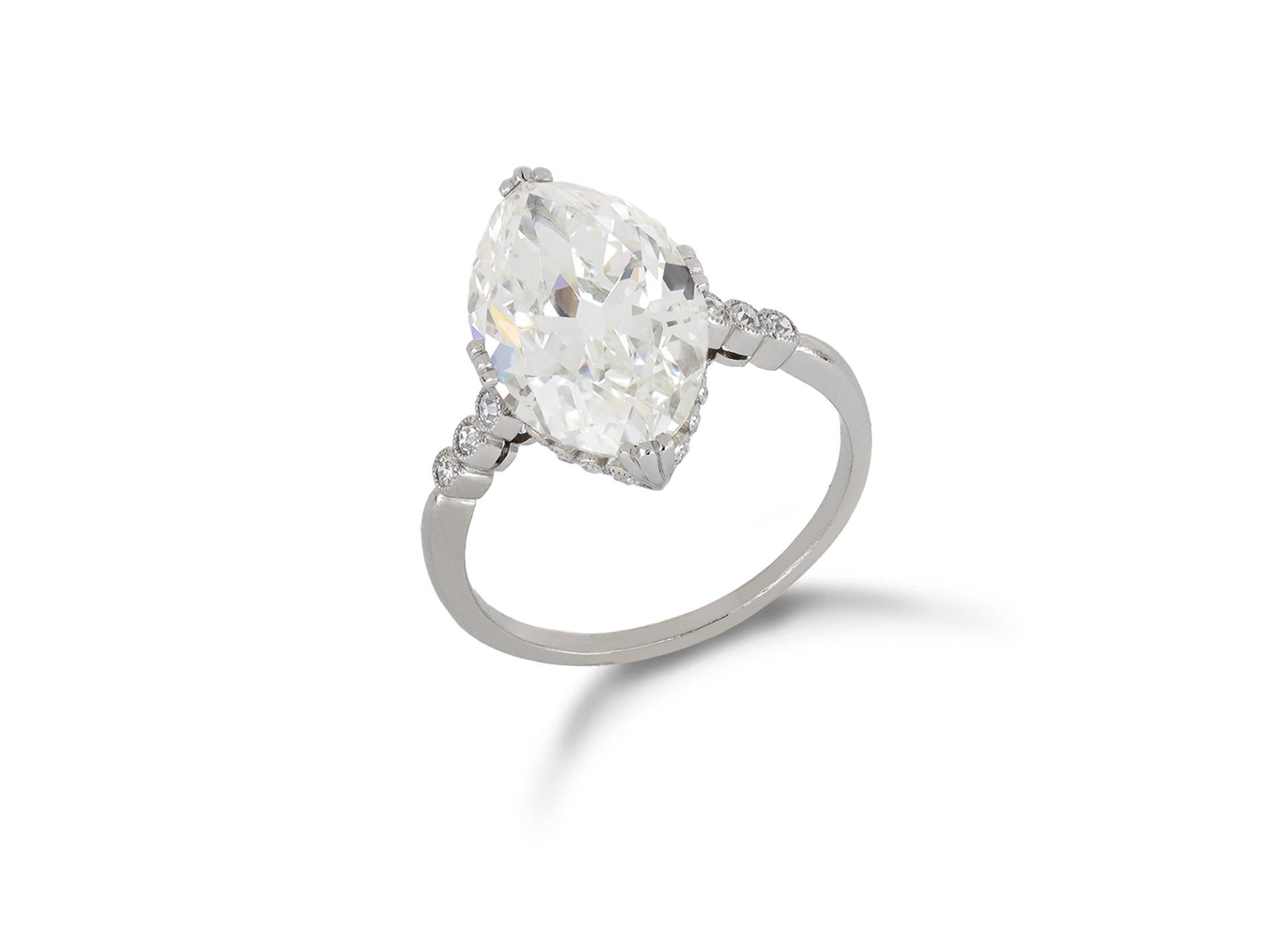 Marquise Shape Diamond Ring. Set to centre with a marquise shape old cut diamond, J colour, VS2 clarity, with a weight of 4.29 carats in an open back claw setting, encircled by twenty single cut diamonds in rubover settings with a combined weight of