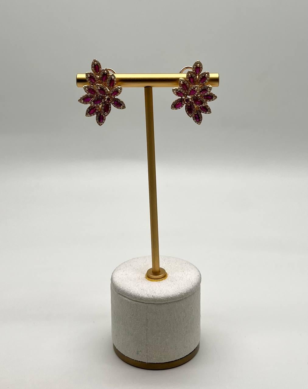 Enhance your elegance with these stunning earrings. Crafted with precision, the earrings feature a floral design adorned with vibrant pink red rubies, creating a captivating sparkle. Surrounded by halo of white diamonds.
Intricate, bold, and