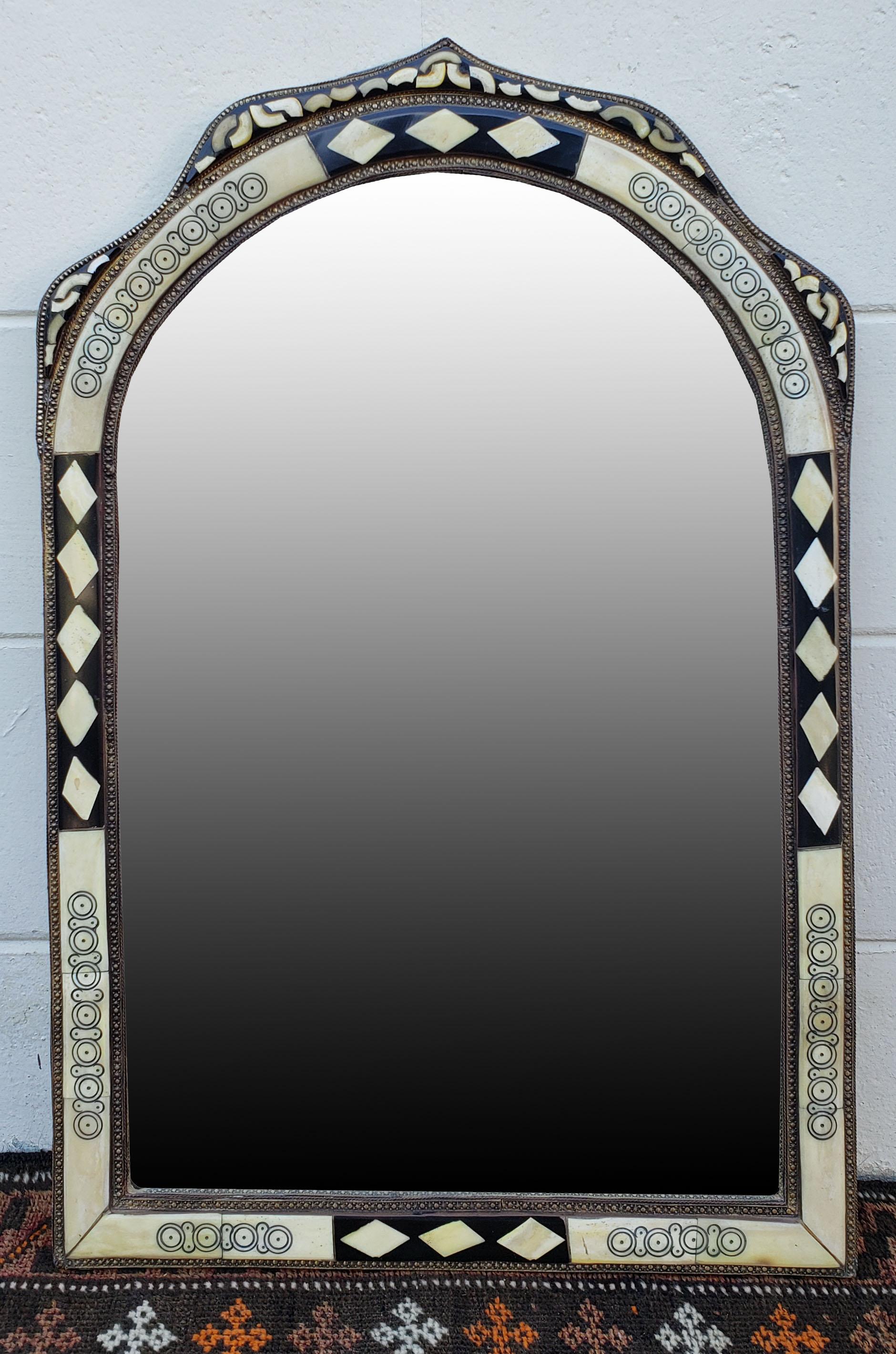 Medium size metal and camel bone inlay Moroccan mirror. Made in the city of Marrakech. Rectangular shape with a arched top, and measuring approximately 29