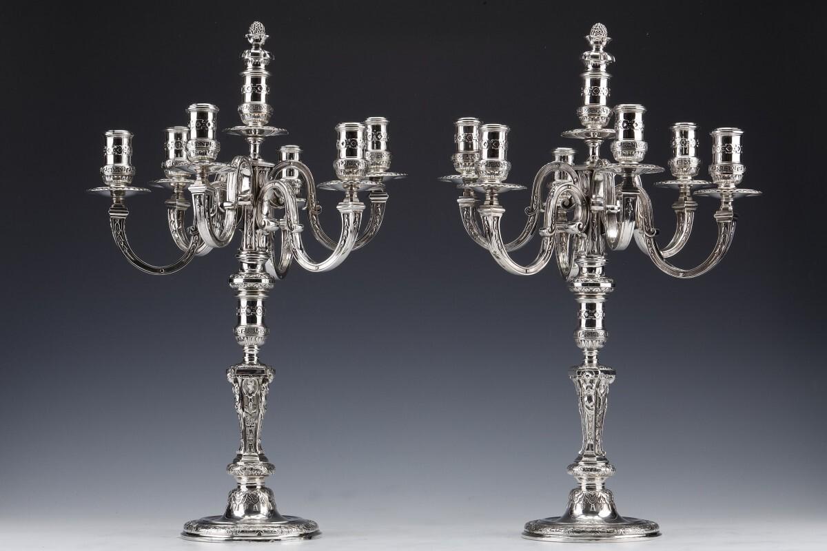 Important pair of solid silver candelabras presenting a removable bouquet with seven arms of light placed on a baluster shaft with a circular base with chiseled decoration of fleurons, scrolls, rosettes, mascarons and Greek friezes.

Dimensions: