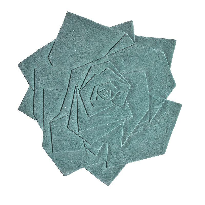 Dieser luxuriöse, aquafarbene Teppich Marry Me mit seinem verblüffenden geometrischen Blütenmuster, das eine raffinierte Rosensilhouette hervorhebt, ist vollständig aus schimmerndem Lurexgarn gefertigt und sorgt für einen eleganten dekorativen