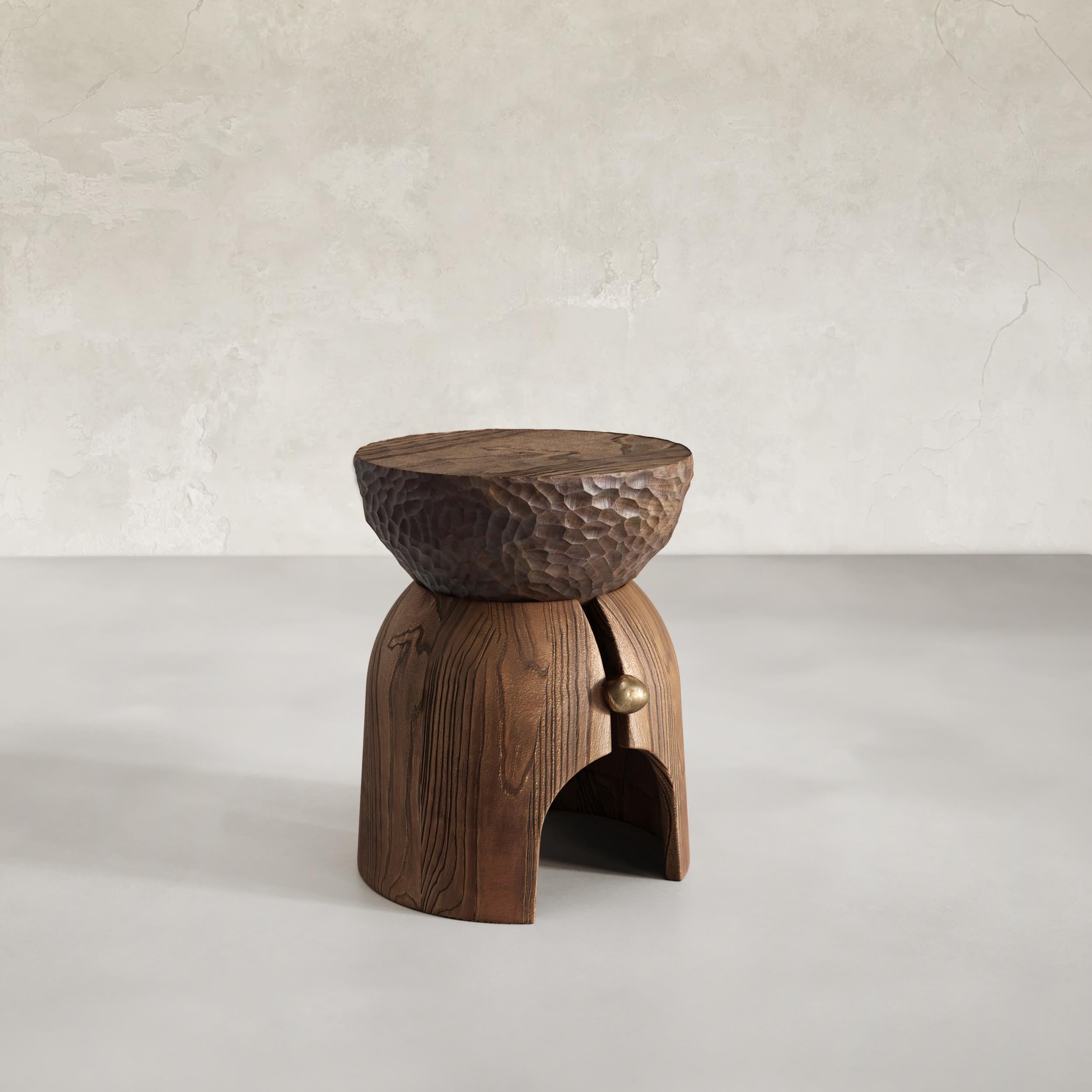 The Mars Side Table is a handcrafted piece of furniture that combines solid wood and liquid bronze for a unique appearance. The table is made using traditional techniques such as hand carving and casting, ensuring that each piece is one-of-a-kind