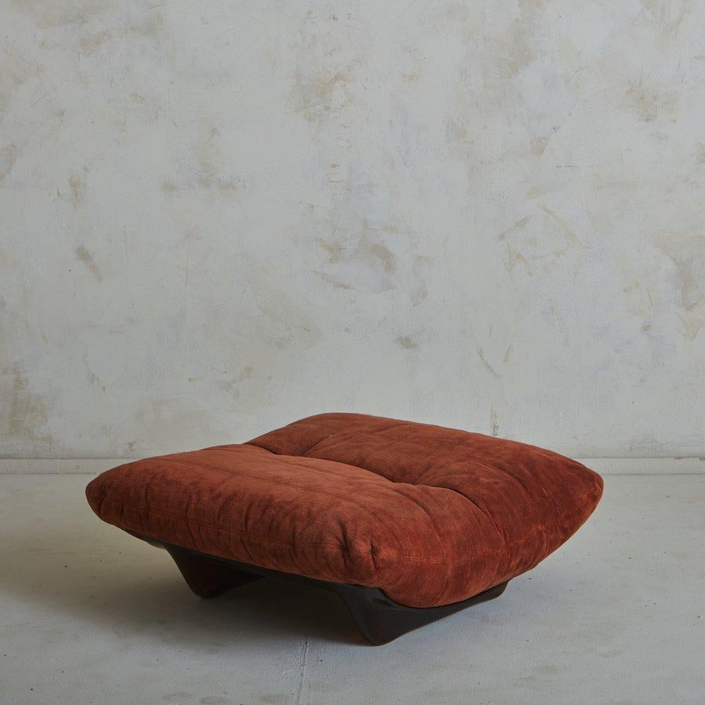 A 1970s French Marsala ottoman designed by Michel Ducaroy for Lignet Roset. This ottoman features a curved amber plexiglass frame and has a removable cushion in original red striated velvet with two button tufts. Retains ‘Lignet Roset Made in