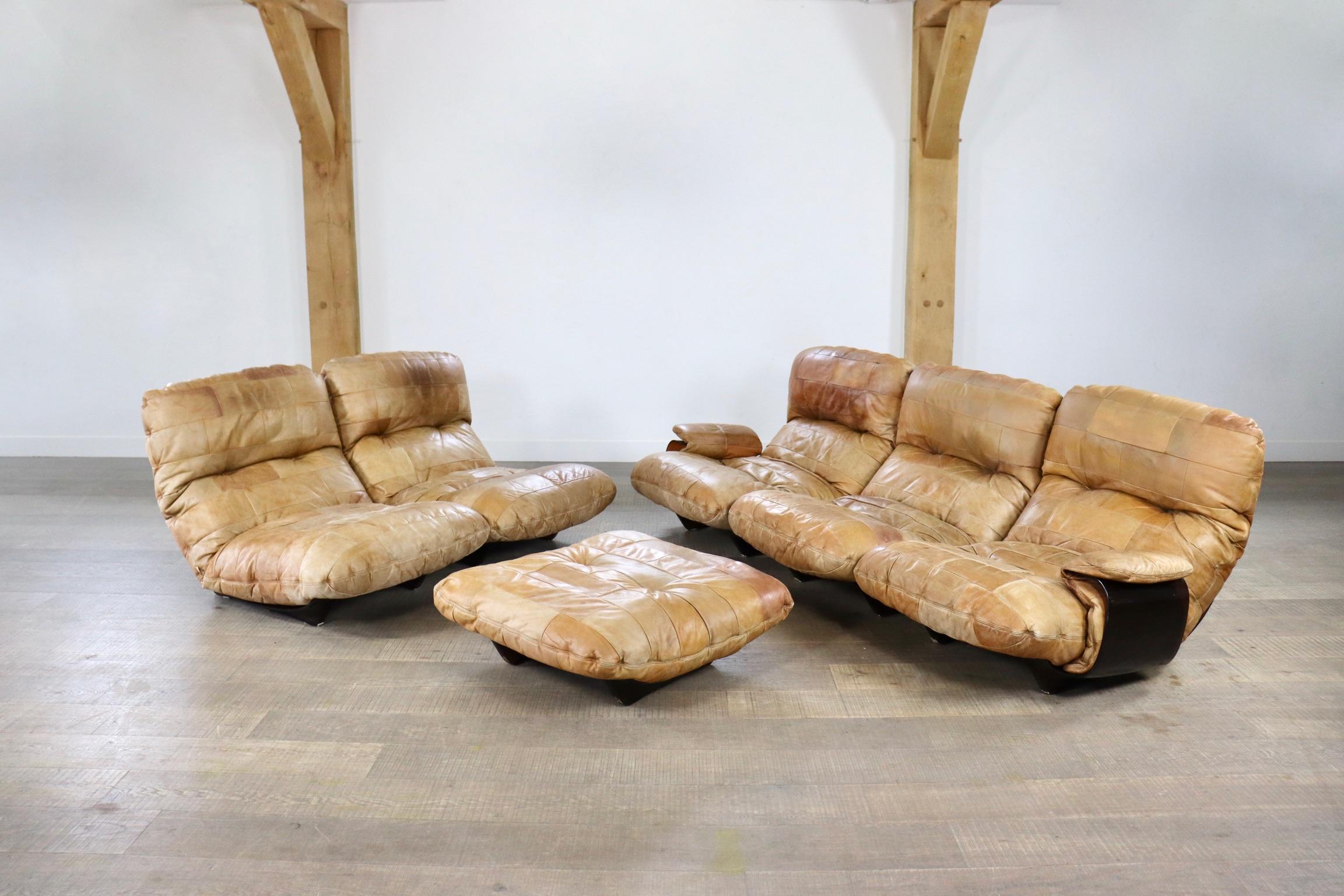 Stunning cognac leather Marsala sofa by Michel Ducaroy for Ligne Roset 1970s. The sofa consists of five oversized leather cushions in a smoke coloured plexiglass shell and one ottoman. The seperate modules allow endless possible settings which makes