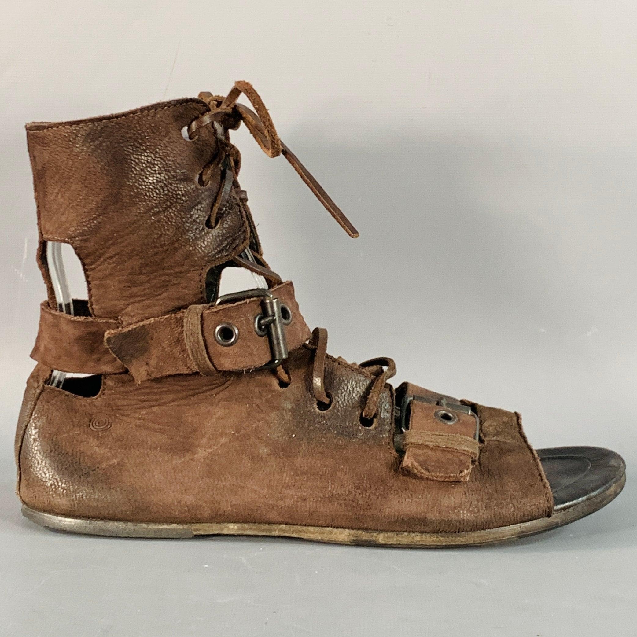 Botas MARSELL
en piel marrón, estilo gladiador con puntera abierta y cierre de cordones con hebilla metálica. Made in Italy. Buen estado de conservación. Signos moderados de desgaste, tal cual. 

Marcado:   IT 37,5 

Medidas: 
  Largo: 9,75 pulgadas