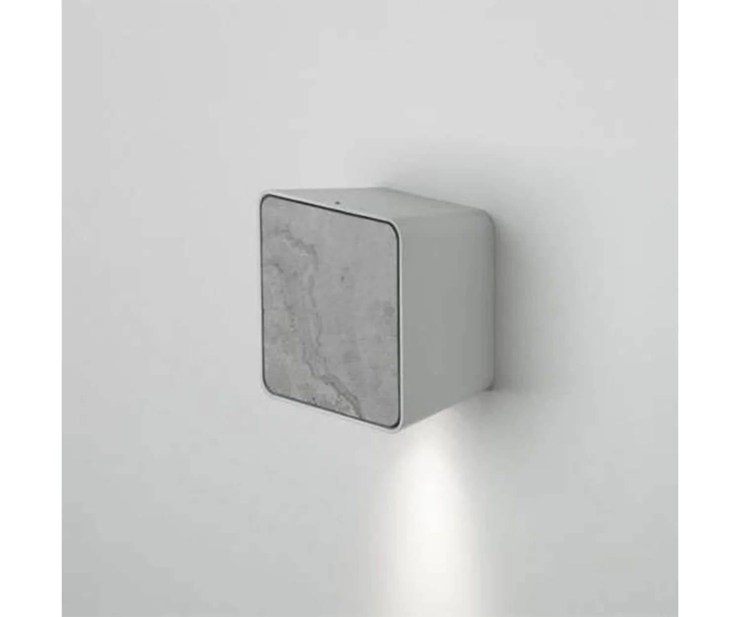 The Lab 2 outdoor wall lamp from the house Marset is characterized by a functional, minimalist design. The structure is available in gray, white or black. In addition, Marset, offers different covers from wood to stone colors, enlarging the