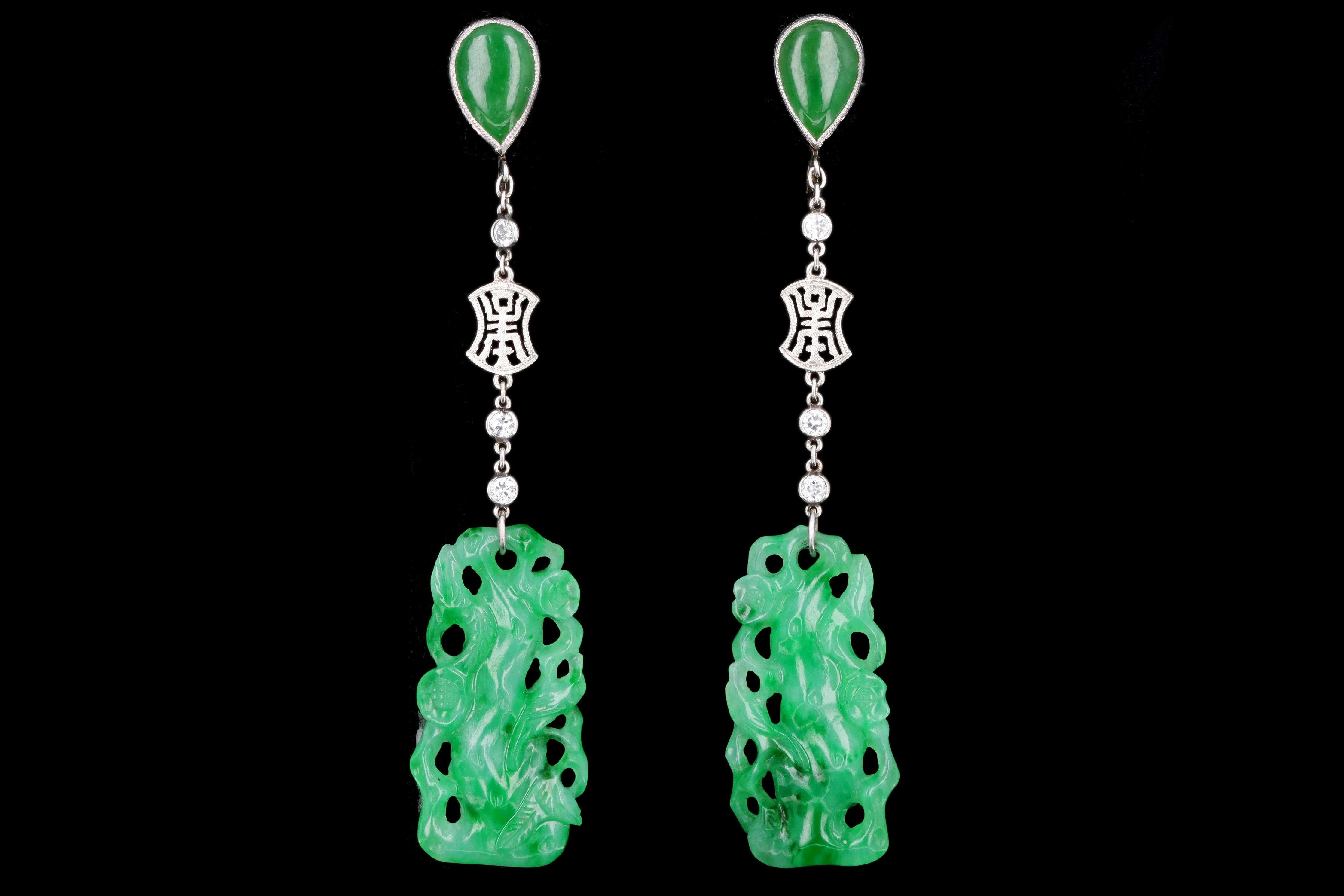 Designer: Marsh & Co.

Era: Art Deco

Composition: Platinum

Primary Stone: 2 Hand Carved Pieces Of Jadeite 

Carat Weight: Approximately 22 Carats

Secondary Stone: 2 Cabochon Pear Cut Jadeite

Carat Weight: Approximately 2.5 Carats

Accent Stone: