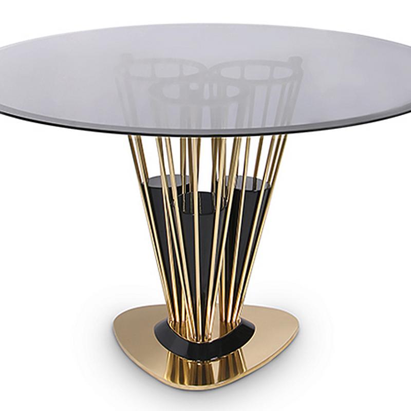 Dinning Table Marshal with tubular conique base structure supported 
by three wood composite in glossy black finish and polished brass.
With a round top in smoked glass.


