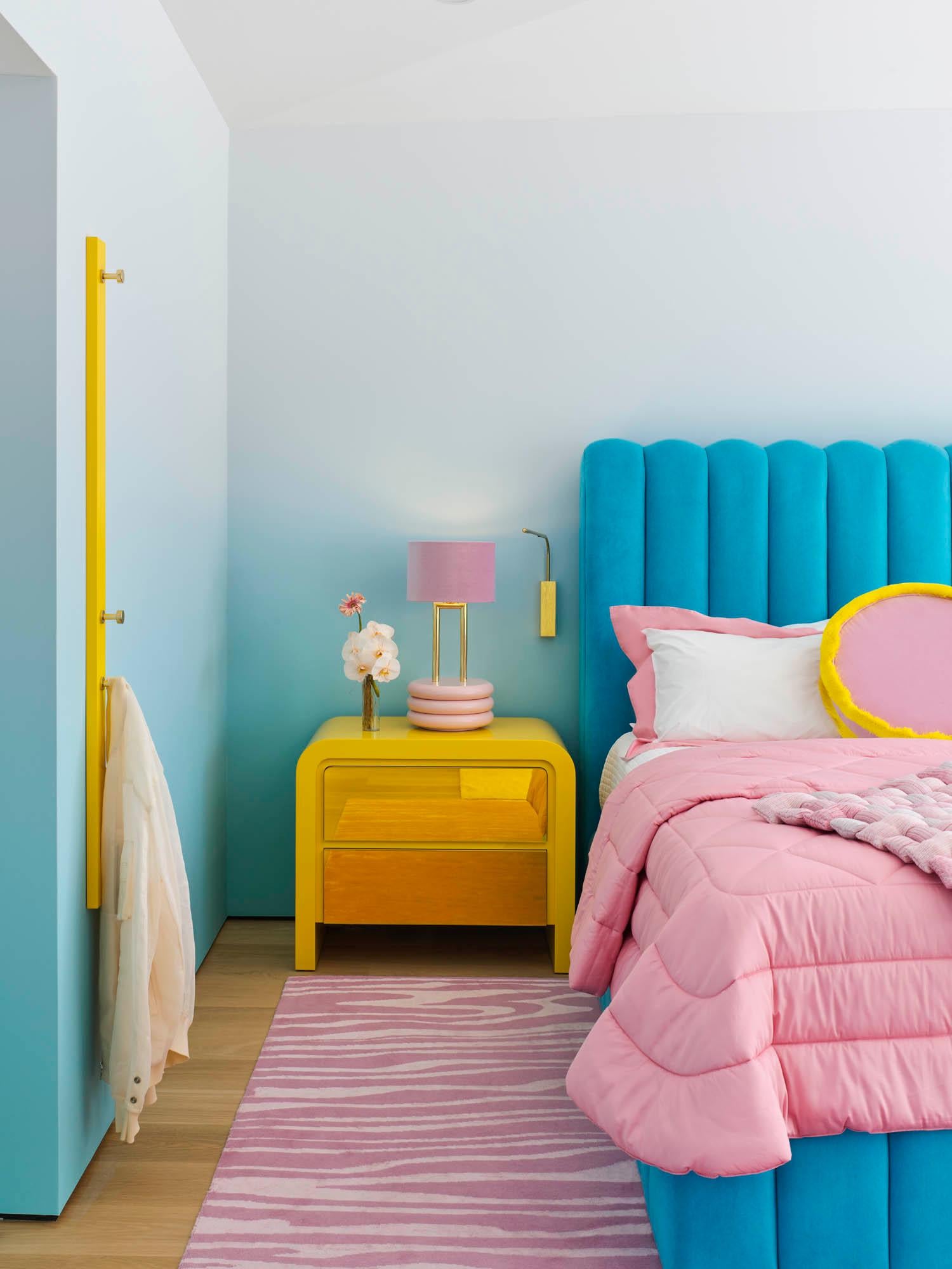 With round shapes and pronounced volume, the Marshmallow Table Lamp stands out for its scale and shape.
A colorful velvet lampshade with gold lining standing on the top of an elegant structure, casts a warm light on the environment.

