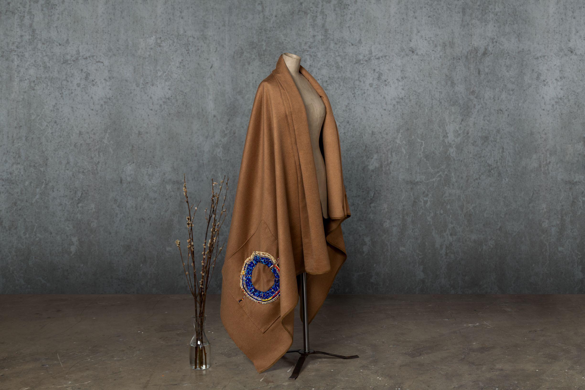 This African design throw from the SoShiro Pok collection is named Marsupia as it is best described as a wraparound cloak – a hybrid of throw and blanket. This cozy cocoon will keep you warm for a stroll with a pleated scarf neckline and a large