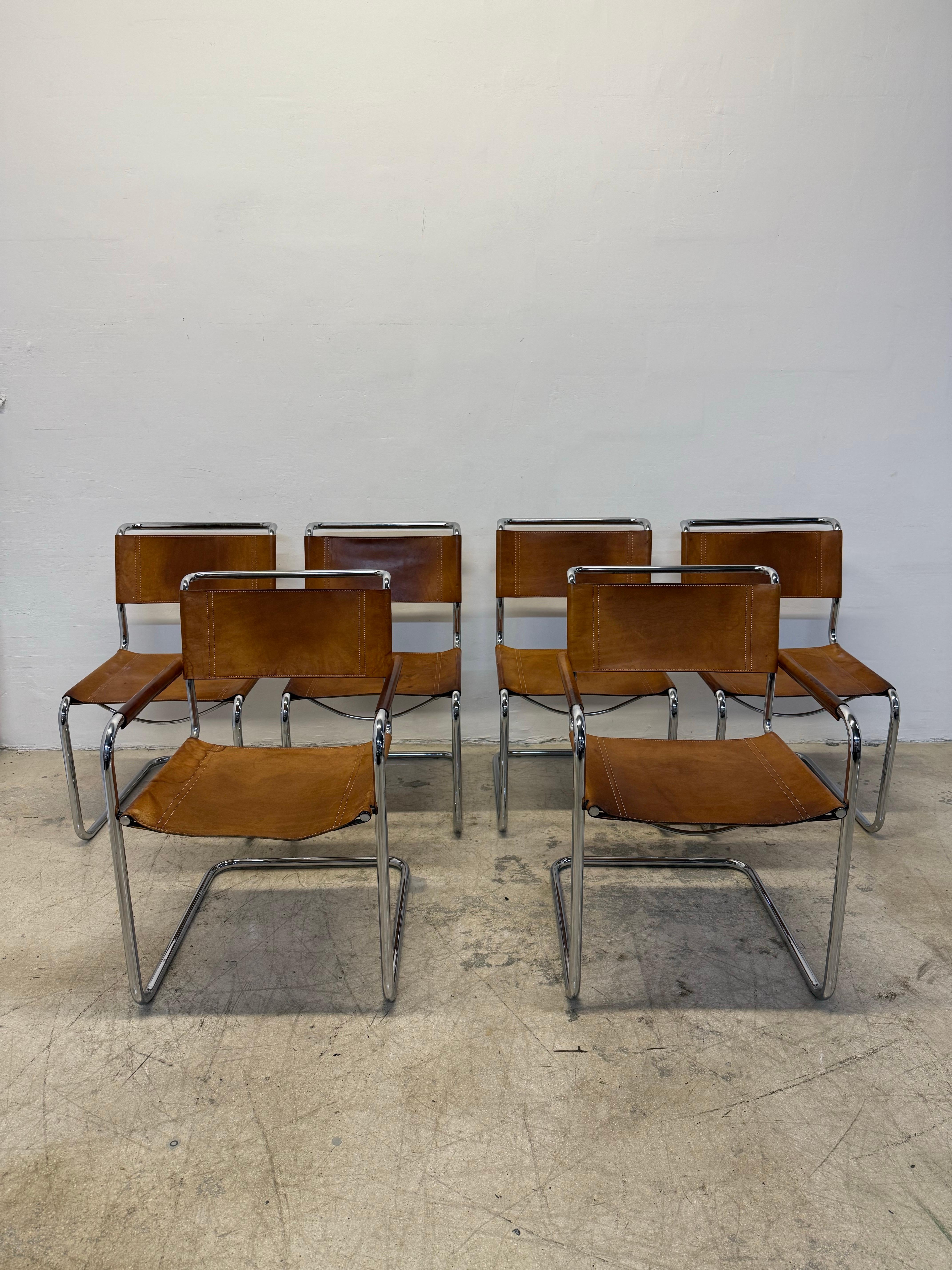 Set of six distressed Cognac leather dining chairs with a tubular chrome frame designed by Mart Stam.  These chairs were manufactured by Thonet circa 1960s.  Two arm chairs and four armless chairs.

2 Arm Chairs
W22.25” D25” H33.75” Sear Height