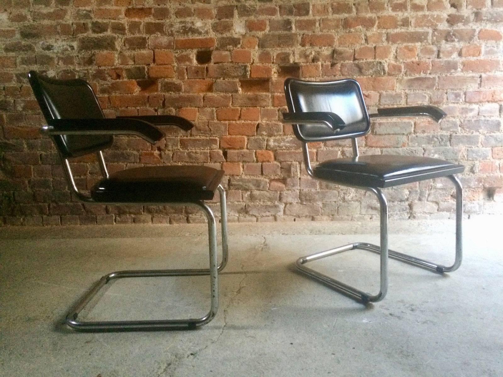 A wonderful pair of midcentury Mart Stam design cantilever armchairs circa 1970s with black leather seats and backrests raised on chrome support with wood armrests, the leather to both chairs is in superb condition with no tears or rips, light scuff