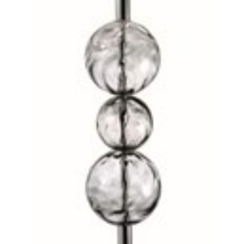 A floor lamp with a very slender stem bearing aligned Venetian crystal spheres worked with the traditional “corteccia” technique. The hot glass is skilfully turned on a flat lamellar plate and then blown to obtain an irregular three-dimensional