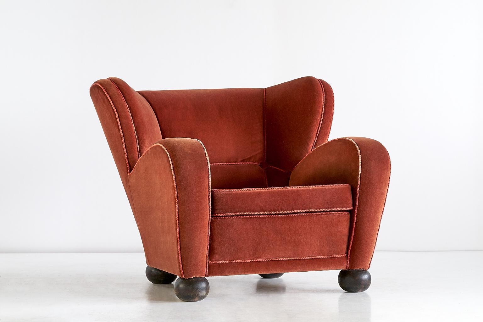 This rare armchair was designed by Märta Blomstedt and produced in Finland in 1939. The generous dimensions and seat depth make this a very comfortable lounge chair. 
The four round bun feet are in stained birch wood. The chair still has its