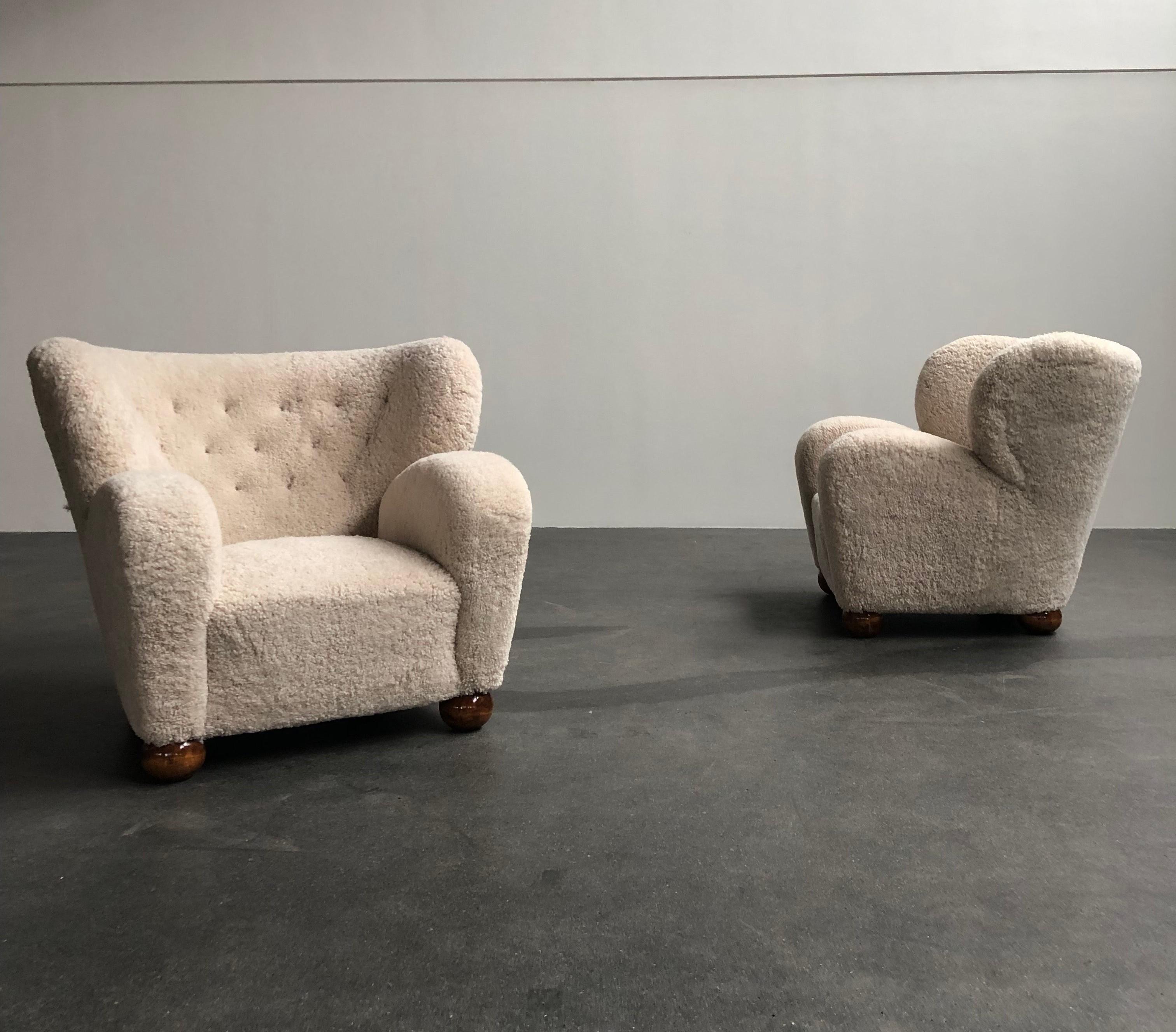 Pair of large Märta Blomstedt easy chairs. Legs in stained ash and upholstered in sheepskin. Model designed for Hotel Aulanko, Finland, 1939.

The chairs are newly refinished an upholstered in sheepskin.

Price is for the pair.