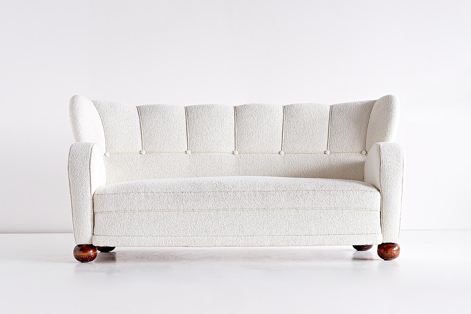 Dieses seltene Sofa wurde von Märta Blomstedt entworfen und in den 1940er Jahren in Finnland hergestellt. Das Sofa wurde komplett überholt und neu mit einem weißen Bouclé-Stoff bezogen. 
Die Architektin Märta Blomstedt, eine der treibenden Kräfte