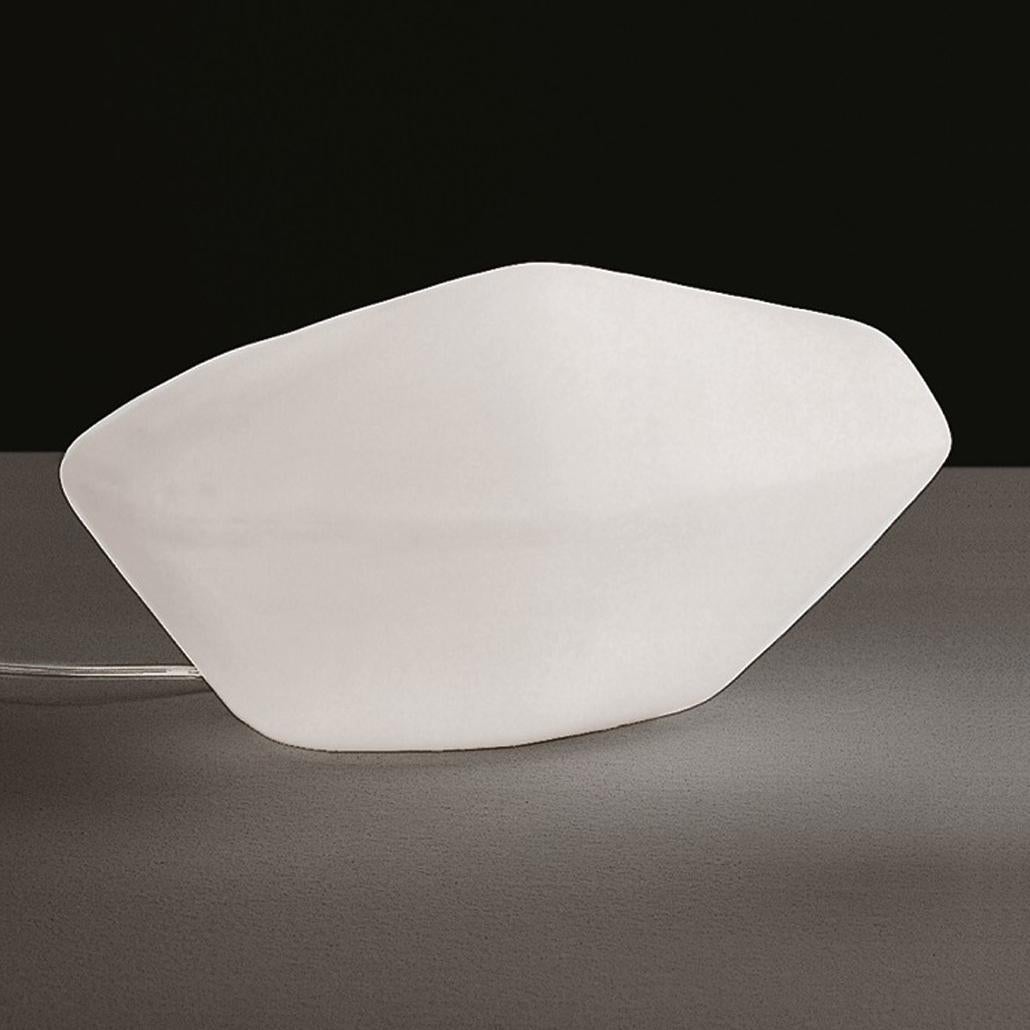 Table lamp 'Stone of Glass' designed by Marta Laudani & Marco Romanelli in 2001.
Lamp to be placed giving diffused light in opaline opaque Murano glass diffuser
Manufactured by Oluce, Italy.

Precious, monolithic objects, the stone of glass