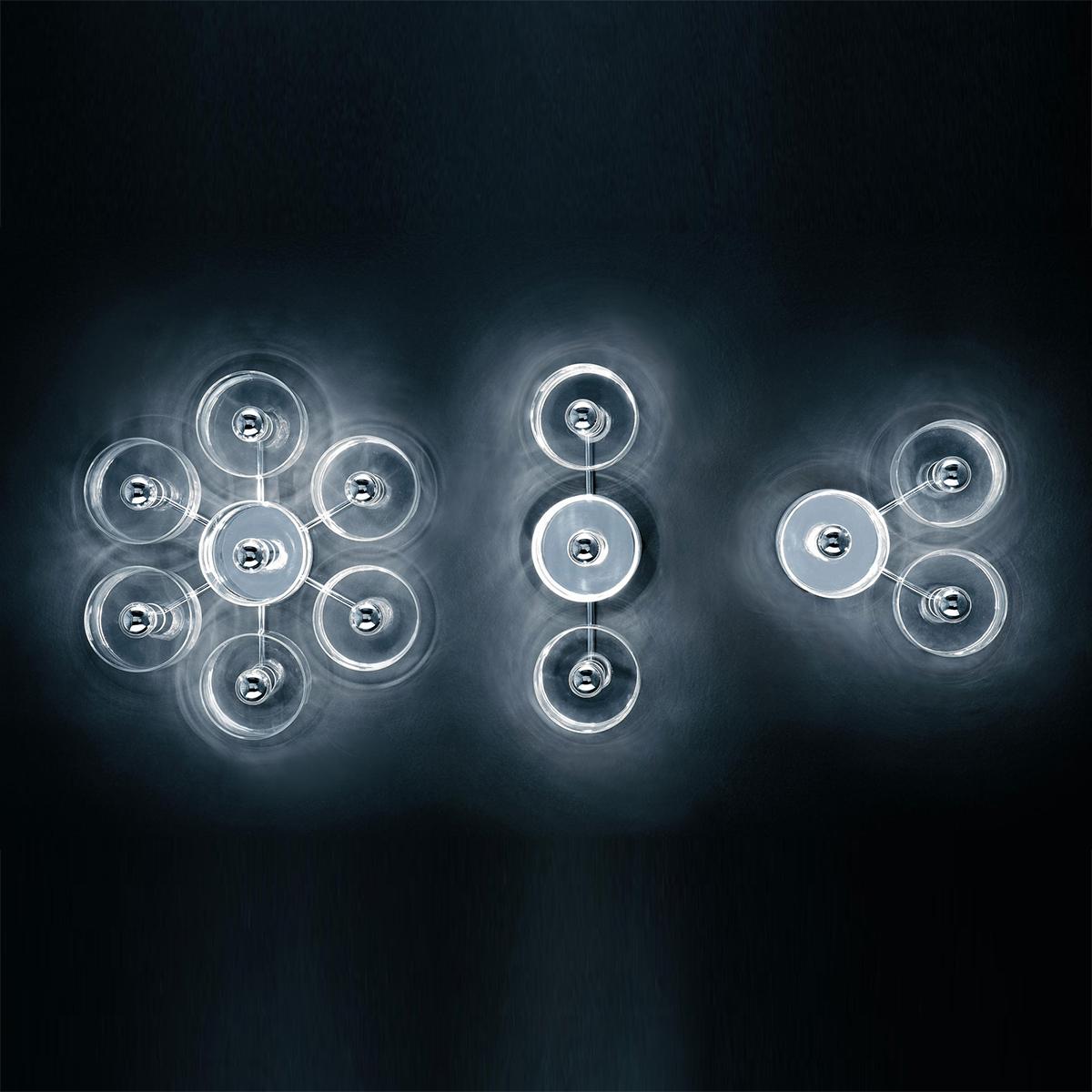 Wall lamp ''Fiore' designed by Marta Laudani & Marco Romanelli in 2007.
Wall and ceiling lamp in transparent blown glass giving direct and diffused light. Chromium-plated metal structure with 7-light on a flower disposition. Manufactured by Oluce,