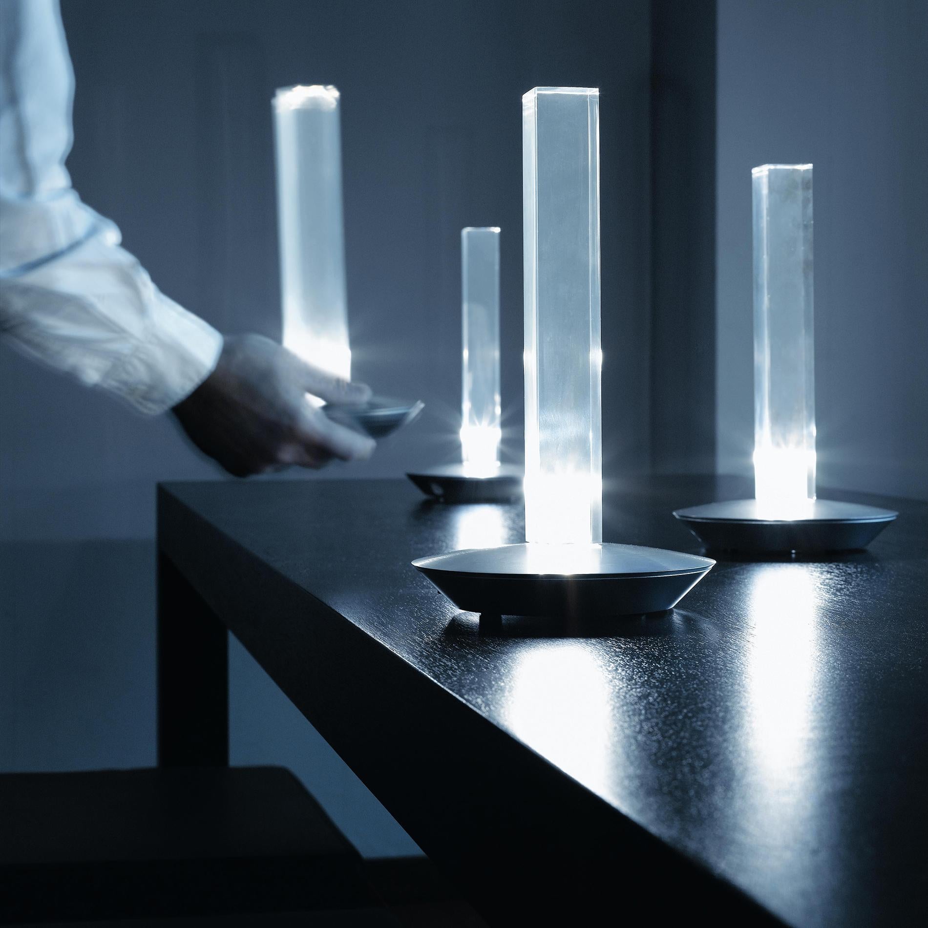 Lampe de table 'Cand-led' conçue par Marta Laudani & Marco Romanel en 2005.
Lampe de table à lumière diffuse, avec LED. Abat-jour en PMMA transparent. Couvercle de base en aluminium anodisé satiné. Avec chargeur de batterie et filtres en plastique
