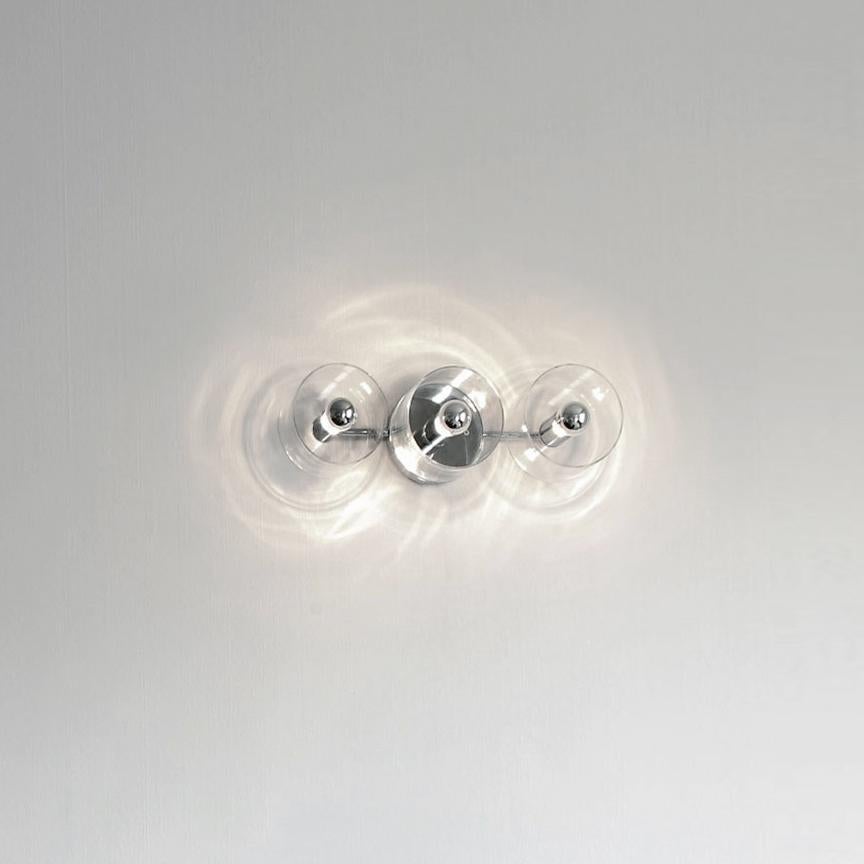 Wall lamp 'Fiore' designed by Marta Laudani & MarCo Romanelli in 2007.
Wall and ceiling lamp in transparent blown glass giving direct and diffused light. Chromium-plated metal structure with 7 lights on a flower disposition. Manufactured by Oluce,