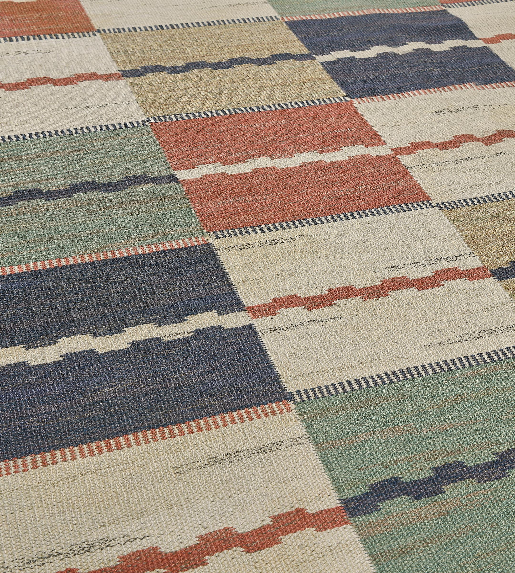 This traditional handwoven Swedish deco rug has a flat-weave polychrome checkered field interrupted by delicate geometric stripes, in a similar whimsical geometric lateral border. This exceptional example of a Swedish Kilim is signed by its artisan