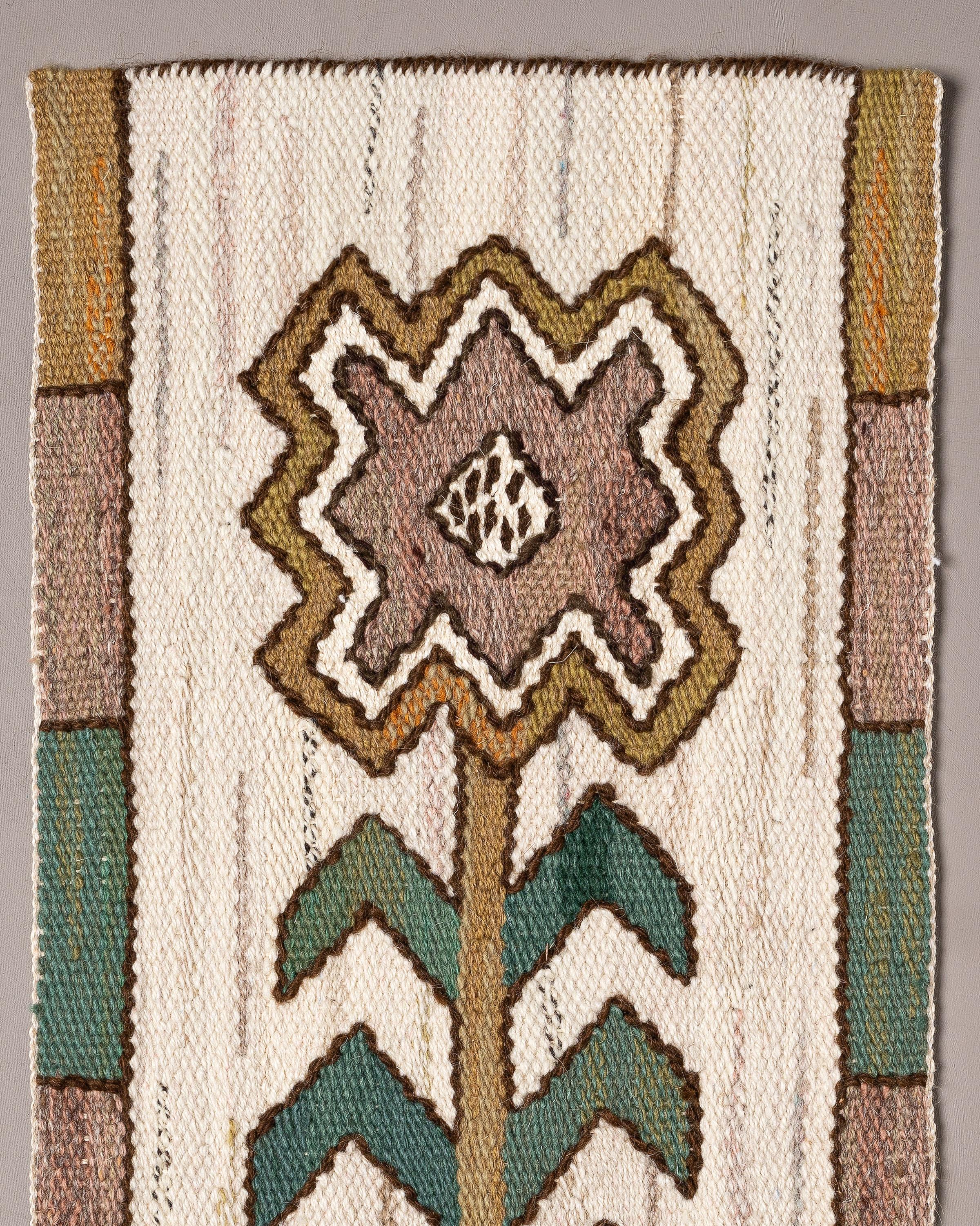 Handwoven tapestry in wool with a lily, designed by Märta Måås-Fjetterström in 1929. Detail from the wall tapestry Sländorna design by MMF. 

Woven in wool on a wool warp by artisan weaver Margareta Westdahl in 2008 at the Märta Måås-Fjetterström