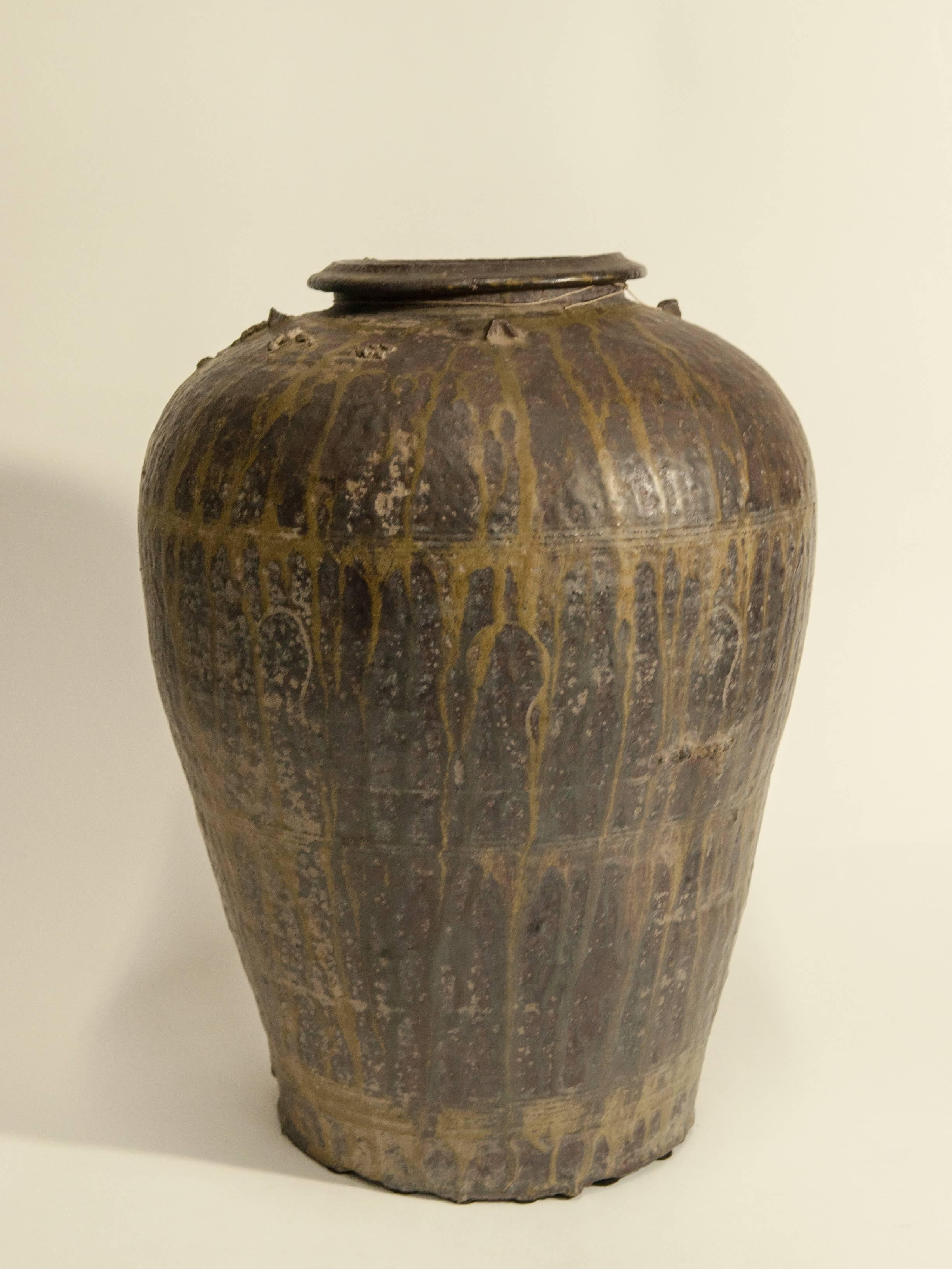 Martaban ware stoneware storage jar with drip glaze. Ming dynasty, found in Laos.
This storage jar, brown with a yellow drip glaze, was recovered in Laos, but most likely manufactured elsewhere -- in southern China during the Ming dynasty; or