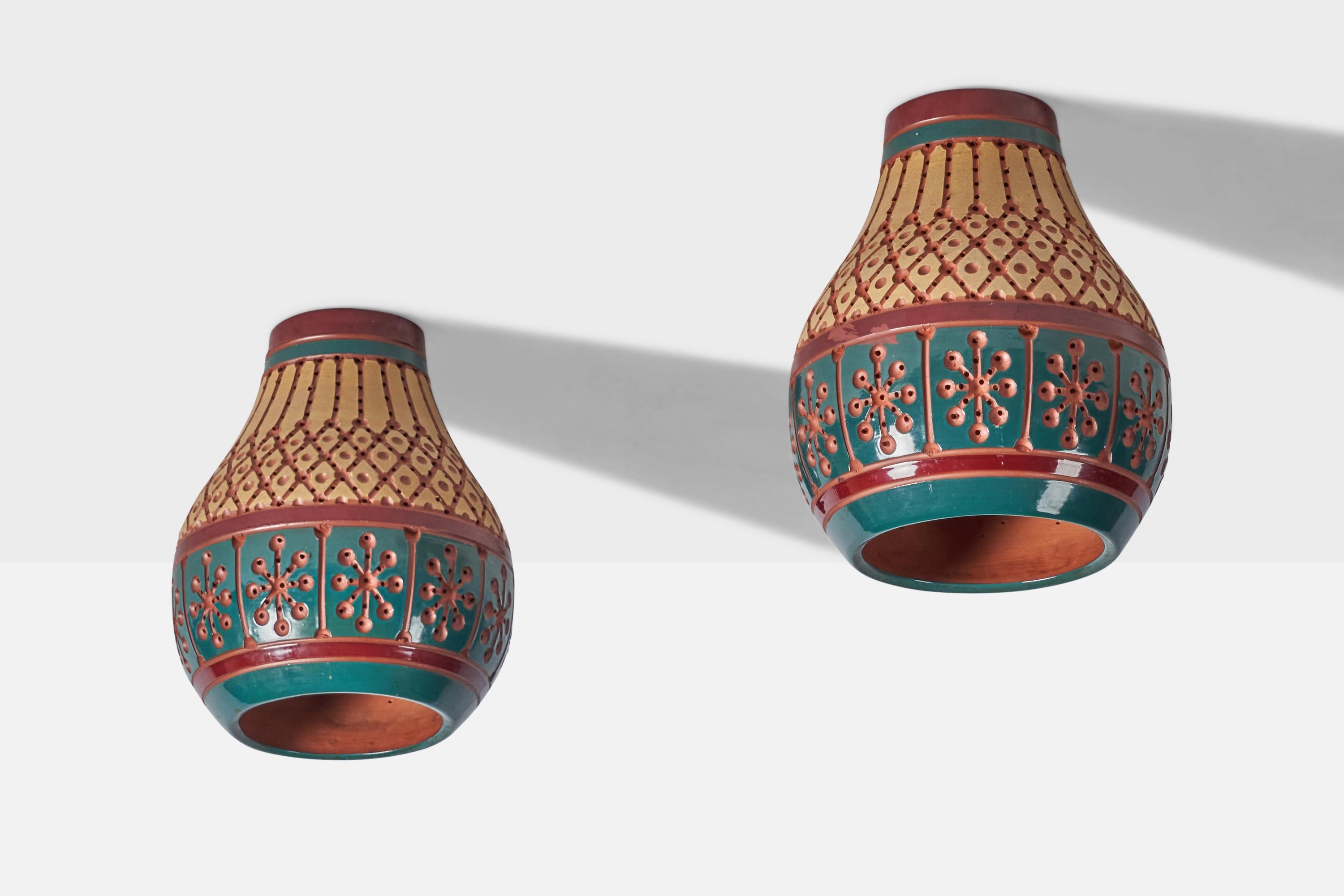 A pair of hand-painted yellow, blue and red flush mounts or pendant lights, designed and produced by Martha & Beaumont Mood, San Antonio, Texas, USA, 1970s.

Overall Dimensions (inches): 12.5” H x 11” Diameter
Bulb Specifications: E-26 Bulb
Number