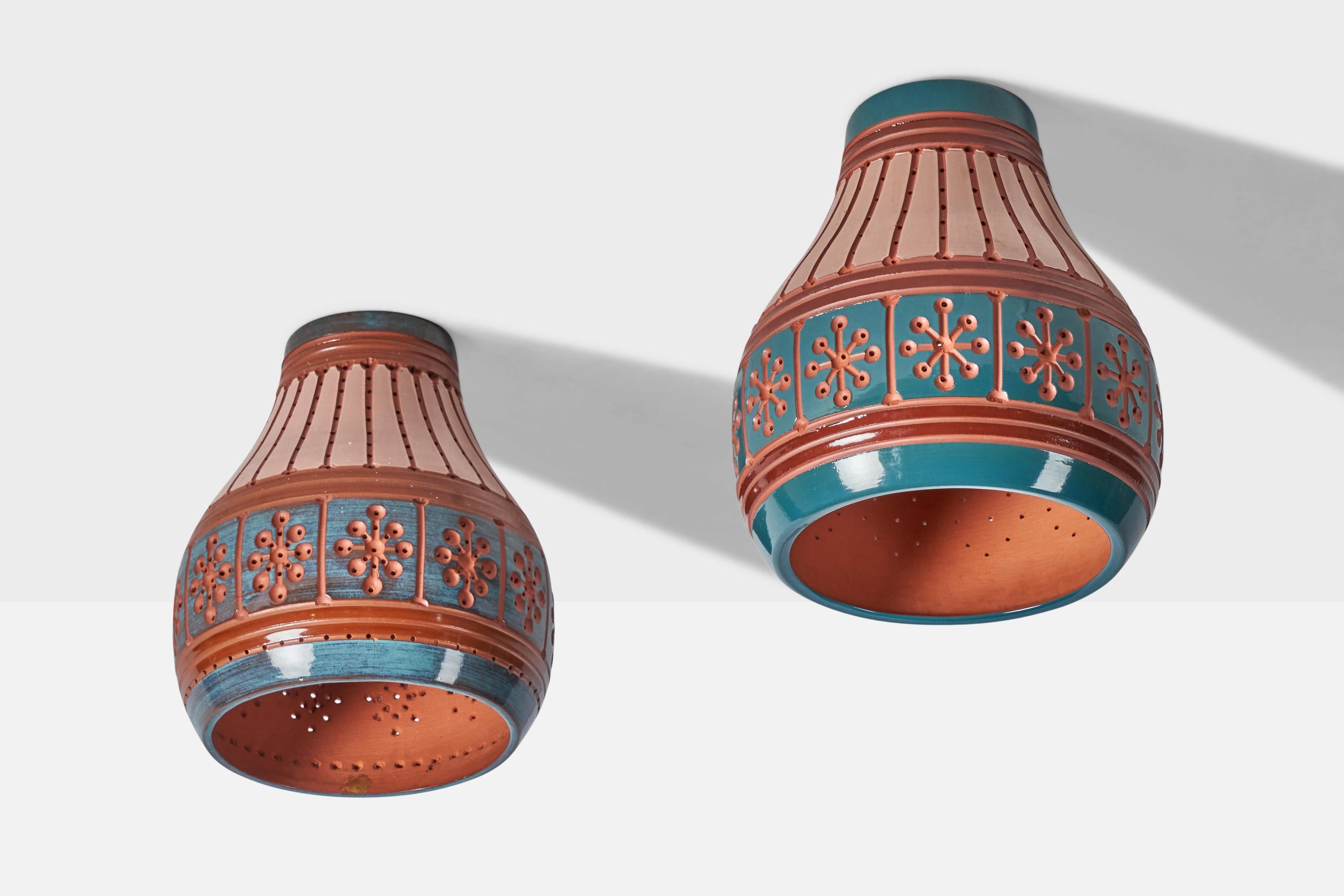 A pair of hand-painted pink, red and blue ceramic flush mounts or pendant lights, designed and produced by Martha & Beaumont Mood, San Antonio, Texas, USA, 1970s.

Overall Dimensions (inches): 12.5” H x 11” Diameter
Bulb Specifications: E-26