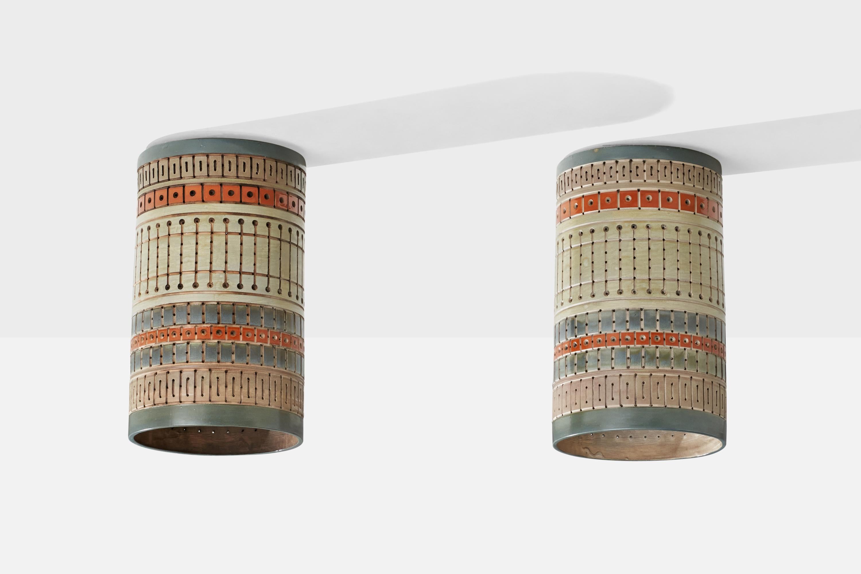 A pair of hand-painted yellow, red and blue ceramic flush mounts or pendant lights, designed and produced by Martha & Beaumont Mood, San Antonio, Texas, USA, 1970s.

Overall Dimensions (inches): 18.25H x 10.75” D
Back Plate Dimensions (inches):