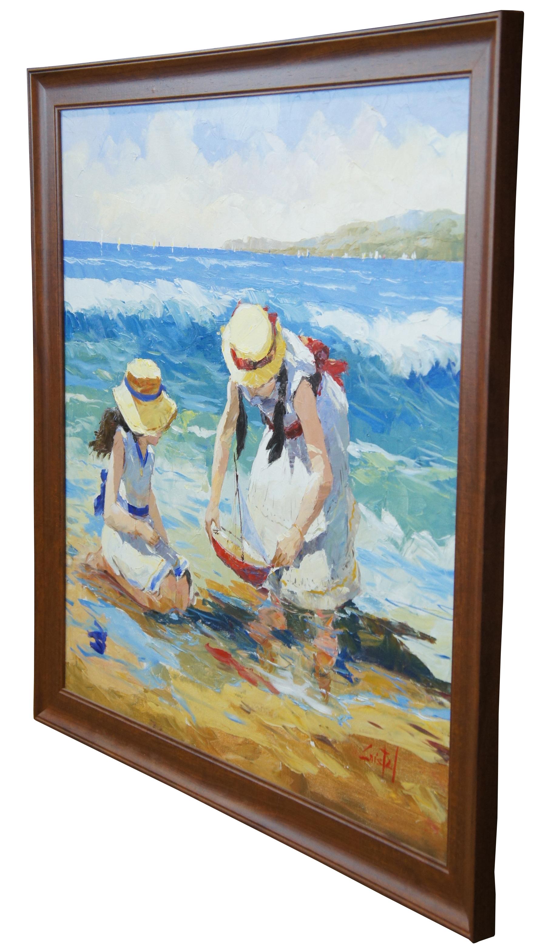 A lovely original oil painting by the Peruvian artist Martha Cristel (b. 1960). Features a mother in daughter in matching sundresses playing in the water by the beach with a toy sailboat. Crashing waves, sailboates and a land mass can be seen in the