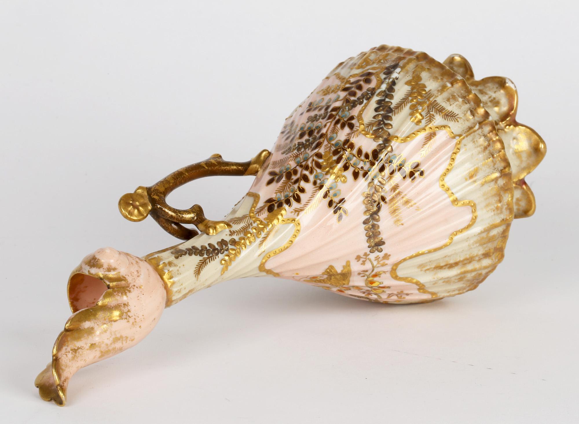 Impresionante aguamanil de mango de porcelana francesa de Limoge pintado a mano con pájaros y arbustos en flor por Martial Redon y datado hacia 1885. El aguamanil se alza sobre un pie moldeado en forma de concha con base rebajada y cuerpo ancho y