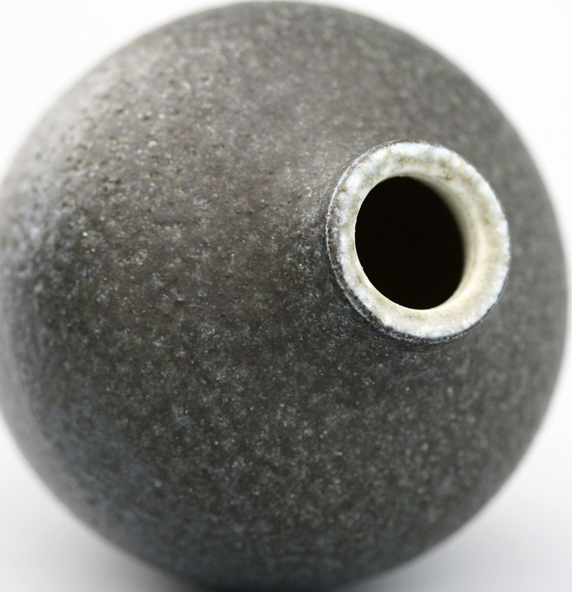 A rare and exceptional Martin Brothers stoneware art pottery rounded shaped vase decorated in textured matte black glazes by Walter Martin and dated 1901. The small rounded heavy stoneware vase is beautifully made stands on a narrow rounded base