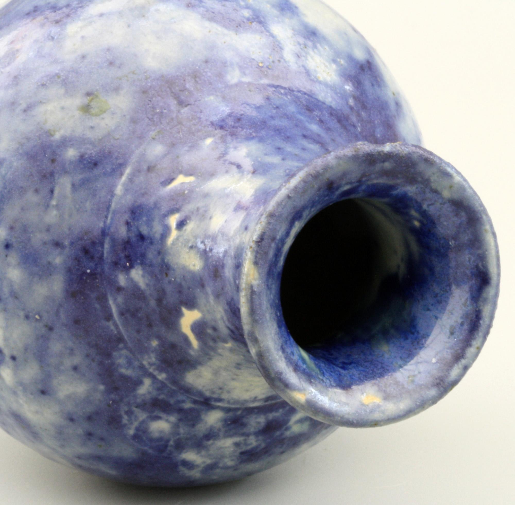 A Martin Brothers stoneware art pottery vase decorated with mottled blue glazes dated 1894. The rounded bulbous vase stands on a narrow rounded base with a narrow raised neck with trumpet shaped top. The vase is decorated with a simple underglaze
