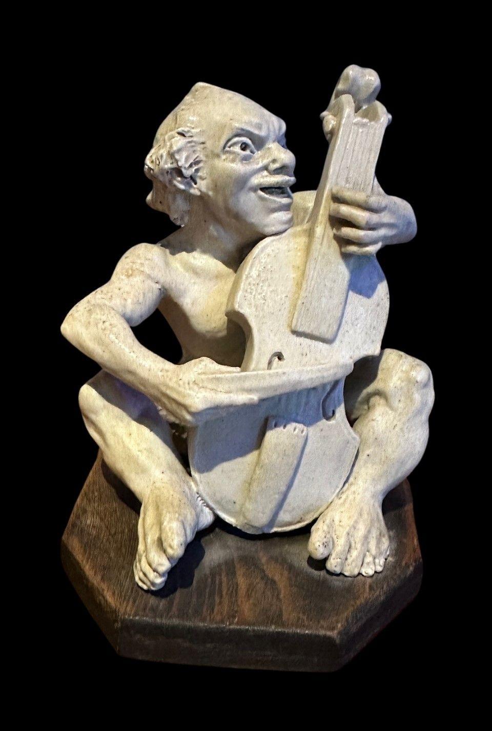 5463
Robert Wallace Martin for the Martin Brothers, a stoneware Musician Imp modelled as a Cellist on a later wooden plinth.
Illustrated in Haslem’s Book “The Martin Brothers Potters”
Minor restoration to two toes
12.5cm high, dated 1906