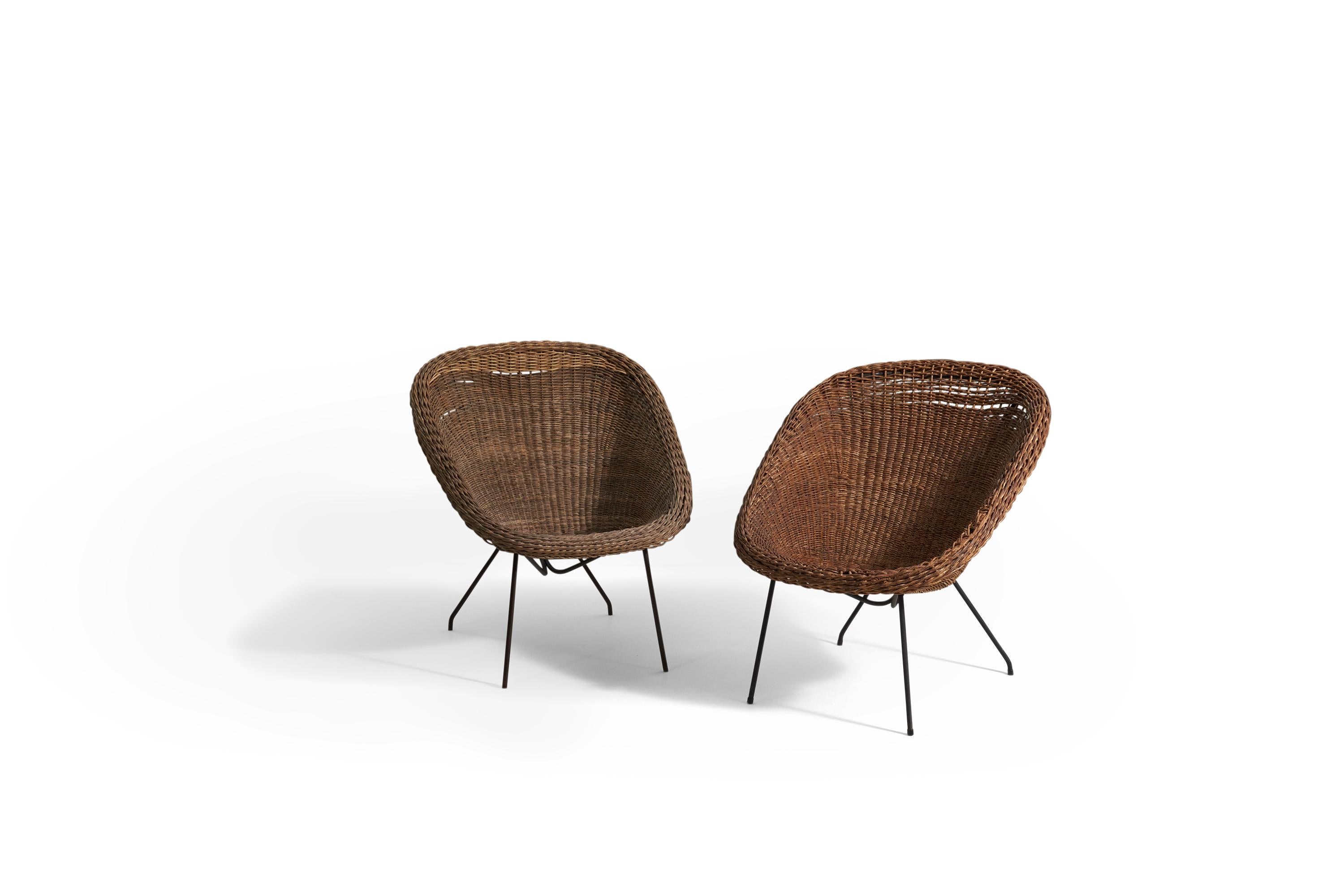 A pair of rattan and steel lounge chairs designed by Martin Eisler and Carlo Hauner and produced by Forma, Brazil, c. 1955. 
