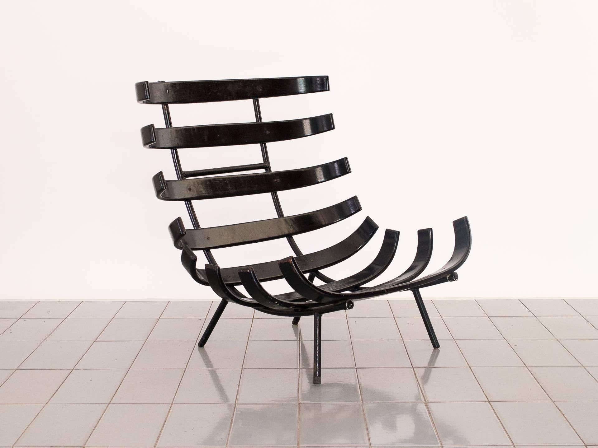 Classic design by Eisler, this chair has tubular iron structure and ebonized wood slats to form seat and back. The cushions still have the original filling, the fabric shows wear but isn't original. This chair hasn't been refinished yet to show the
